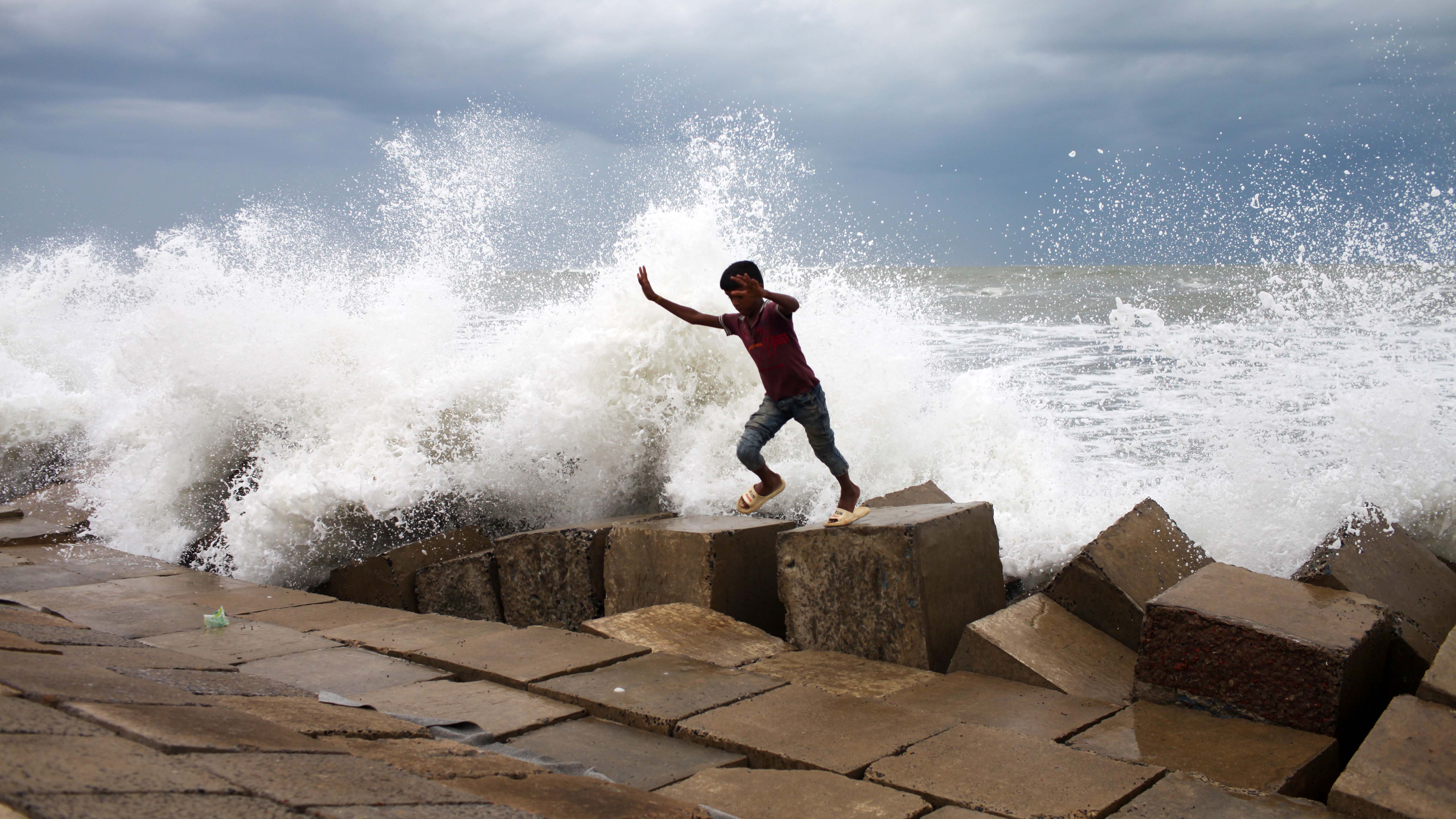 13.05.2023, Bangladesch, Dhaka: Ein Junge flieht vor dem Wind und den Wellen, ausgel&ouml;st durch den Zyklon&nbsp;Mocha. Die Beh&ouml;rden in Bangladesch und Myanmar bereiten sich auf die Evakuierung von Hunderttausenden von Menschen vor, da sie sich auf einen schweren Zyklon im Golf von Bengalen vorbereiten. Foto: Abu Sufian Jewel/ZUMA Press Wire/dpa +++ dpa-Bildfunk +++