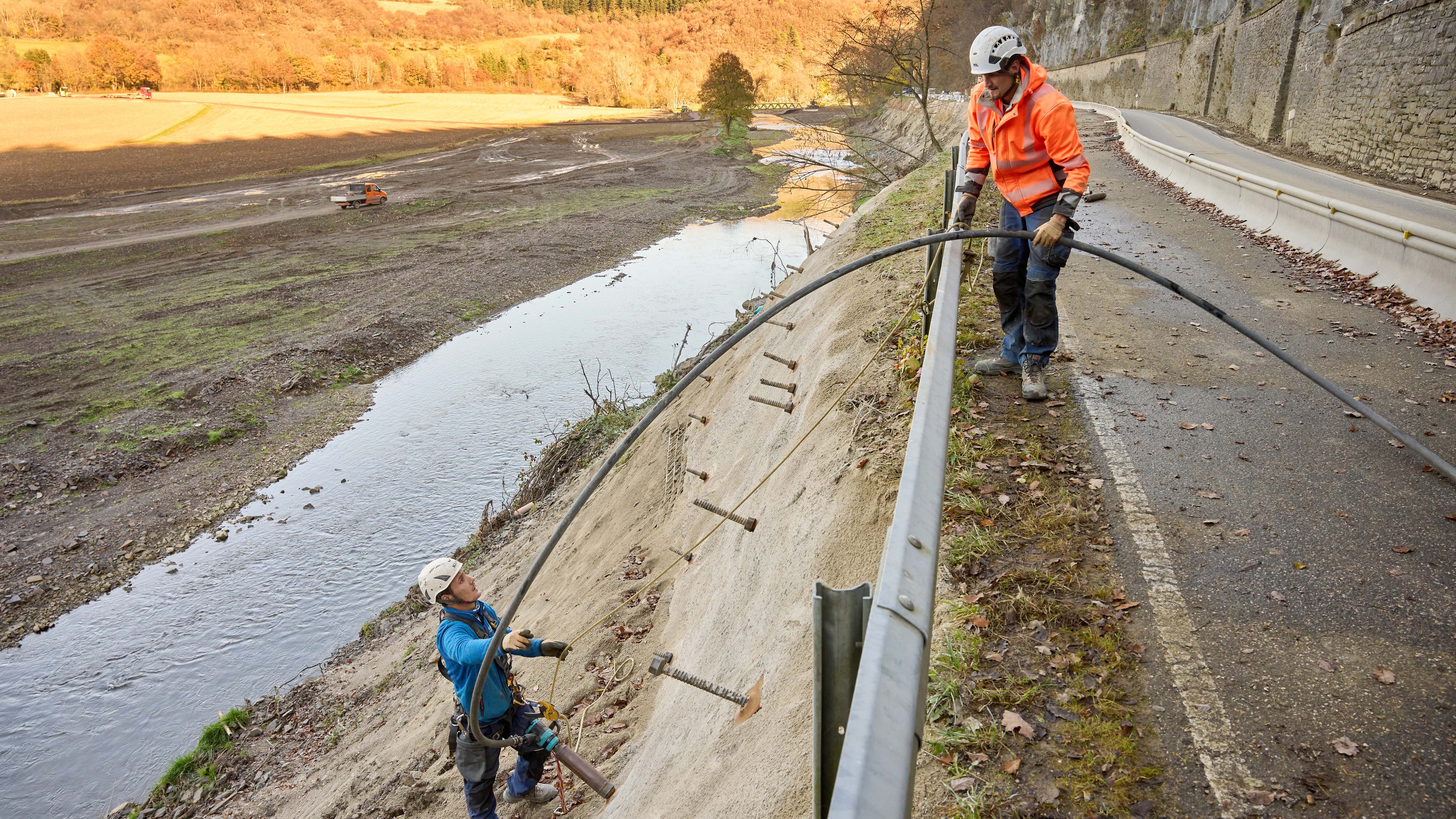 09.11.2021, Rheinland-Pfalz, Schuld: Arbeiter errichten an der Landesstrasse 73 zwischen Insul und Schuld eine St&uuml;tzmauer zur Ahr hin. Die Stra&szlig;e wurde bei der Flutkatastrophe untersp&uuml;lt. Das Hochwasser im Ahrtal hat auch das Stra&szlig;ennetz verw&uuml;stet. Nach notd&uuml;rftigen L&ouml;sungen wollen Experten es nun winterfest machen. (zu dpa "Provisorische Stra&szlig;en im Ahr-Flutgebiet sollen winterfest werden") Foto: Thomas Frey/dpa +++ dpa-Bildfunk +++