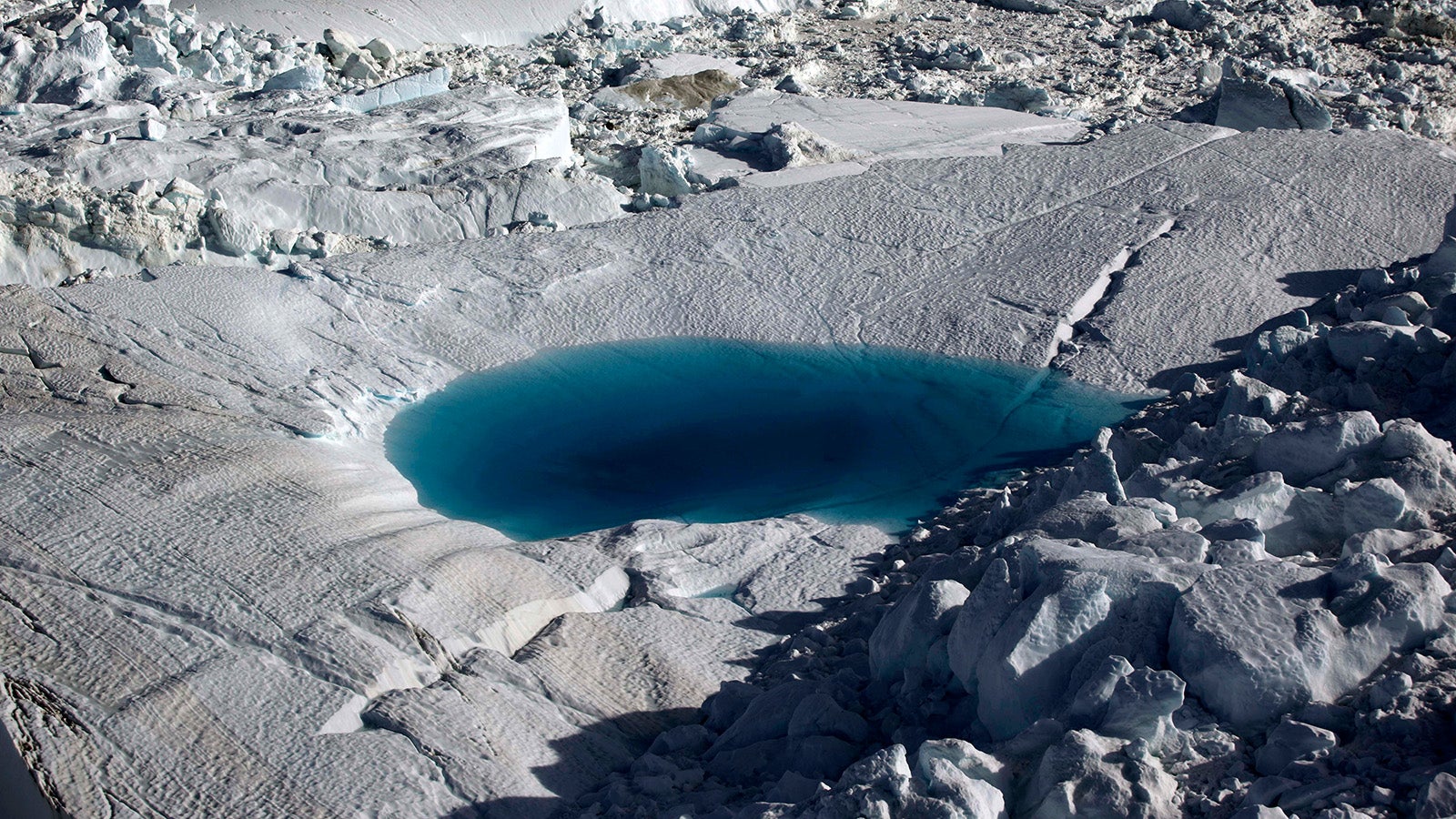 FILE - In this July 19, 2011 file photo, a large melt pool forms in the Ilulissat ice fjord below the Jakobshavn Glacier, at the fringe of the vast Greenland ice sheet. The Arctic is warming three times faster than the rest of the planet and is on such a knife&rsquo;s edge of survival that the 2021 U.N. climate negotiations in Scotland could make the difference between ice and water at the top of the world in the same way that a couple of tenths of a degree matter around the freezing mark, scientists say. (AP Photo/Brennan Linsley, File)