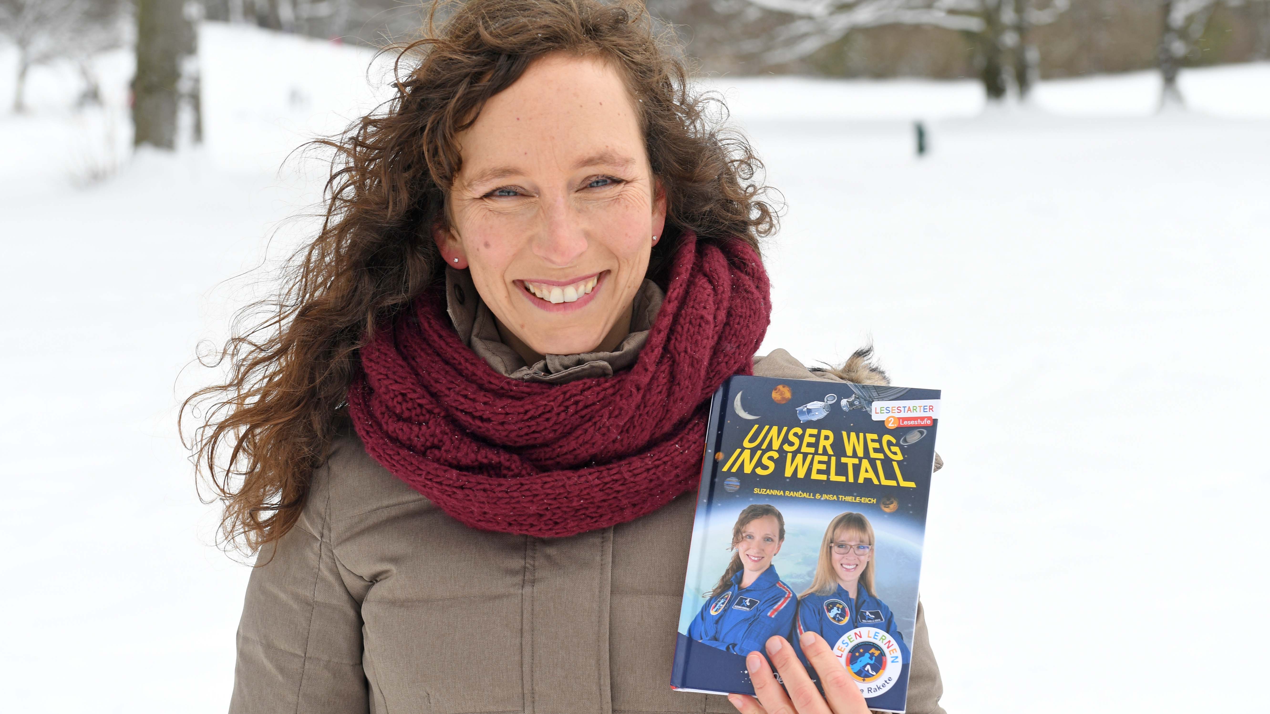 ARCHIV - 26.01.2021, Bayern, M&cedil;nchen: Die Astronautin Suzanna Randall steht im verschneiten Englischen Garten mit dem Kinderbuch "Unser Weg ins Weltall" das sie zusammen mit ihrer Kollegin Thiele-Eich geschrieben hat (zu dpa &acute;Auf dem Weg zur Astronautin - Randall und ihr Traum im Lockdown&ordf;). Foto: Felix H&circ;rhager/dpa +++ dpa-Bildfunk +++