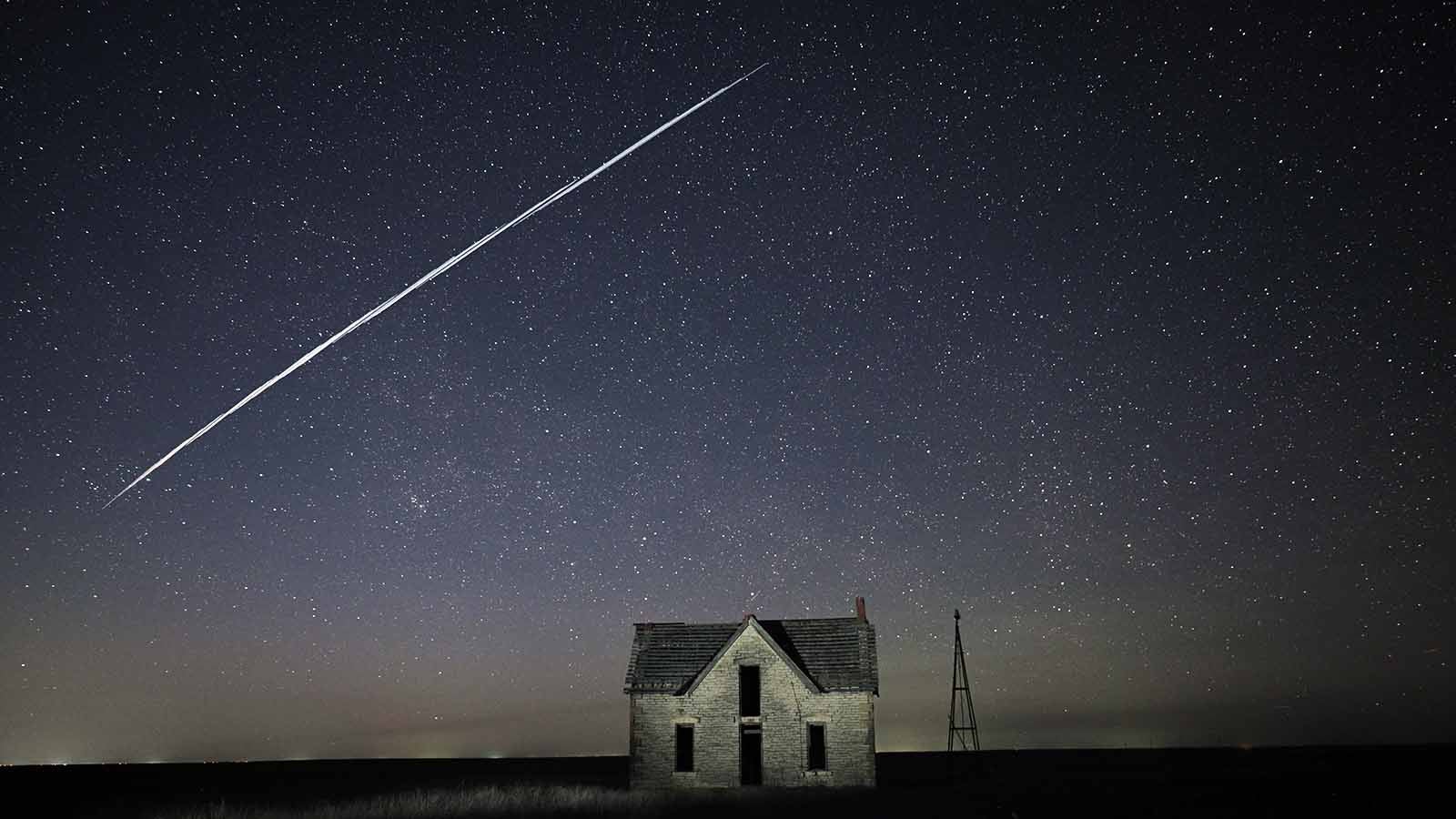 File-In this photo taken May 6, 2021, with a long exposure, a string of SpaceX StarLink satellites passes over an old stone house near Florence, Kan. The train of lights was actually a series of relatively low-flying satellites launched by Elon Musk's SpaceX as part of its Starlink internet service earlier this week.  (AP Photo/Reed Hoffmann, File)