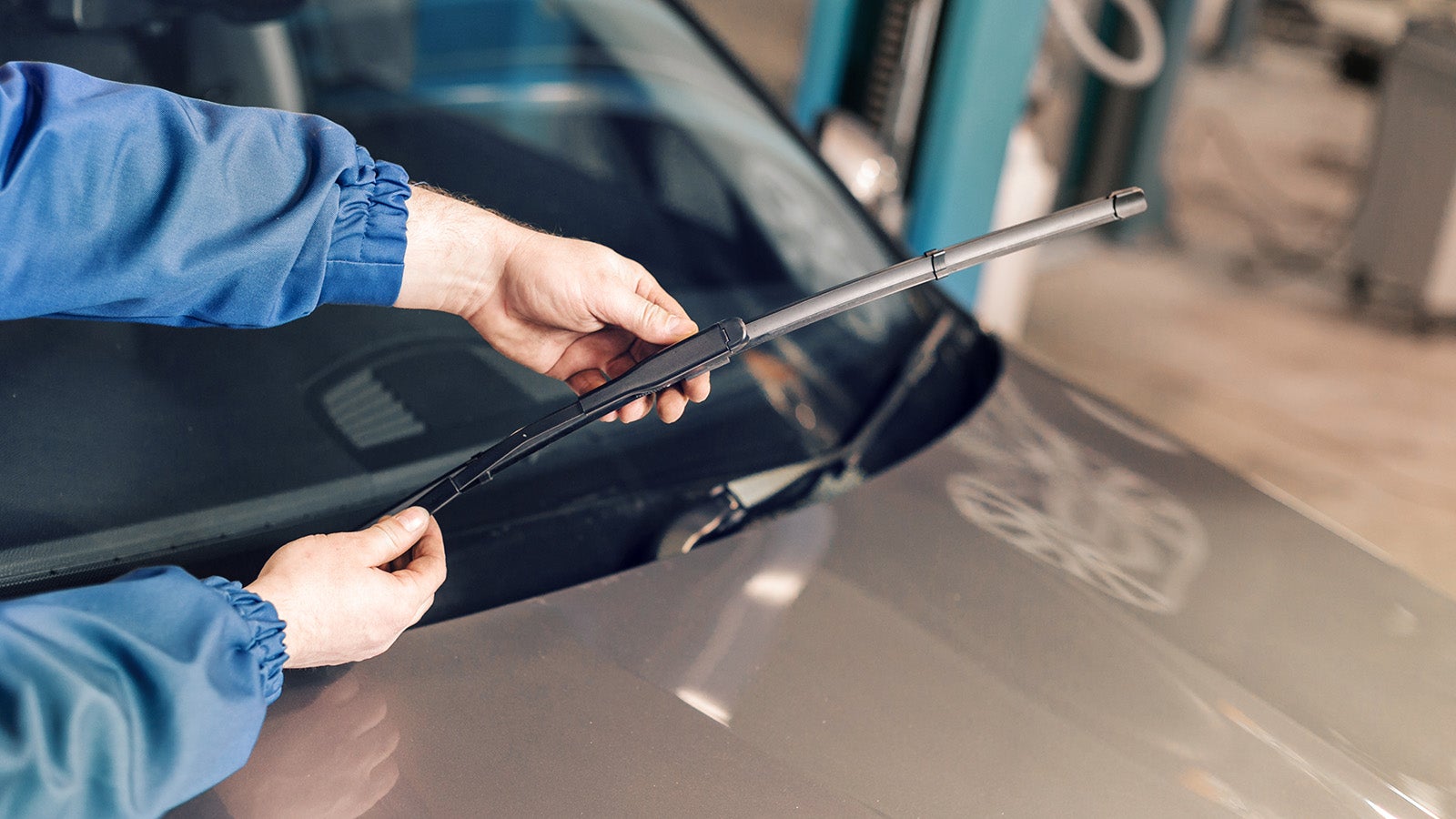 Technician is changing windscreen wipers on a car station