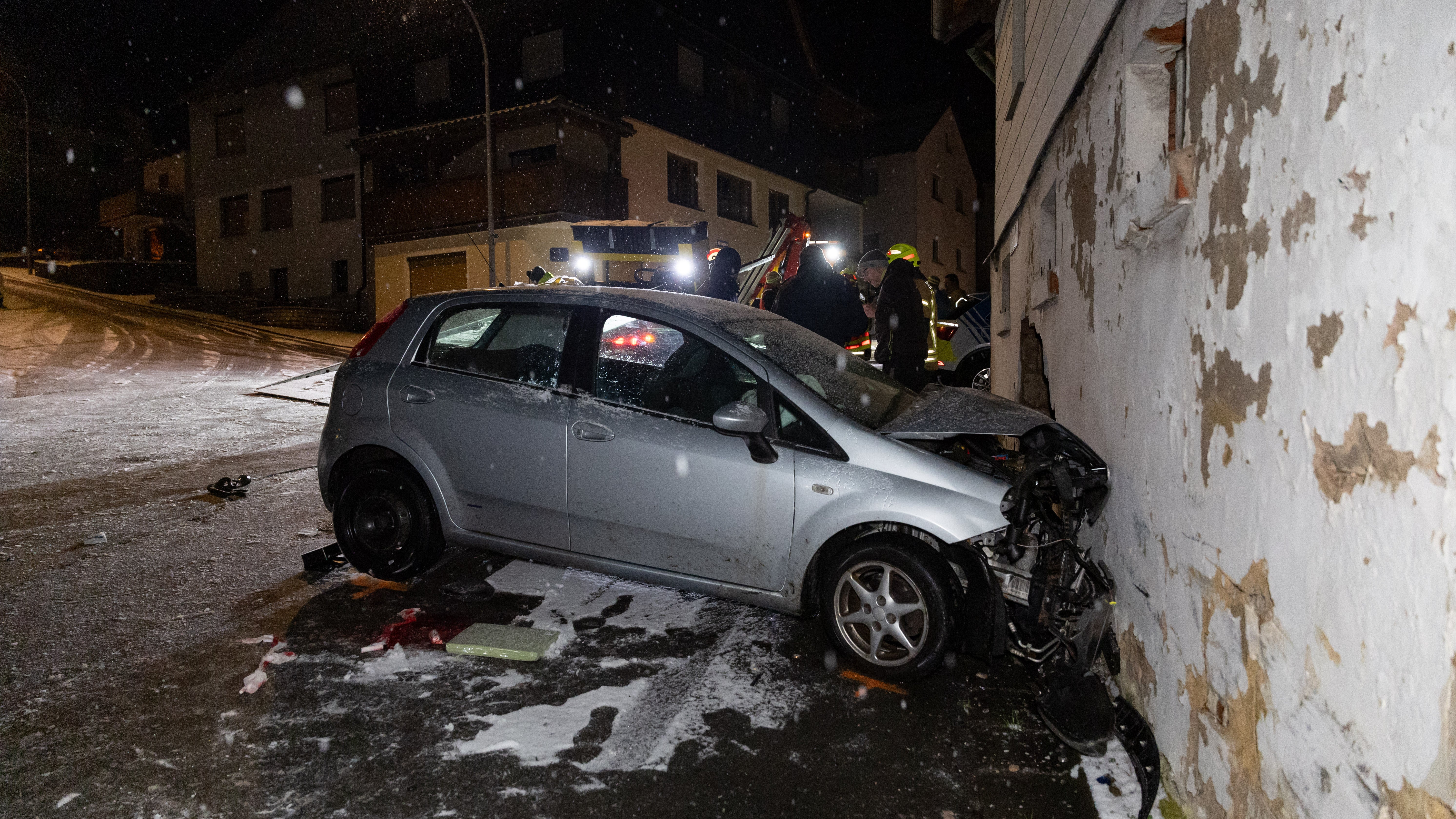 03.01.2025, Bayern, Sonnefeld: Ein Auto steht bei Gl&auml;tte und Schneefall nach einem Unfall an einer Hauswand. Das Auto war in Oberfranken mit solcher Wucht gegen eine Hauswand gekracht, dass das leerstehende Geb&auml;ude jetzt mit einer St&uuml;tzkonstruktion gesichert werden muss. Bei dem Unfall in Sonnefeld (Landkreis Coburg) erlitten drei Autoinsassen leichte Verletzungen, ein vierter wurde schwer verletzt. (Steffen Ittig/NEWS5/dpa)


