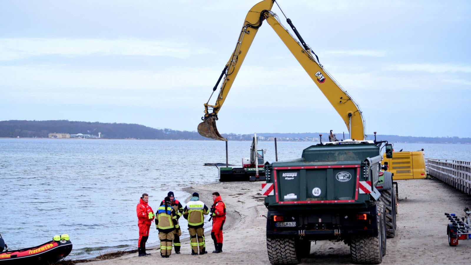 26.03.2026, Schleswig-Holstein, Timmendorfer Strand: Helfer stehen am Strand in der N&auml;he des gestrandeten Wals. Heute soll ein neuer Rettungsversuch f&uuml;r das Tier unternommen werden. Foto: Daniel Bockwoldt/dpa