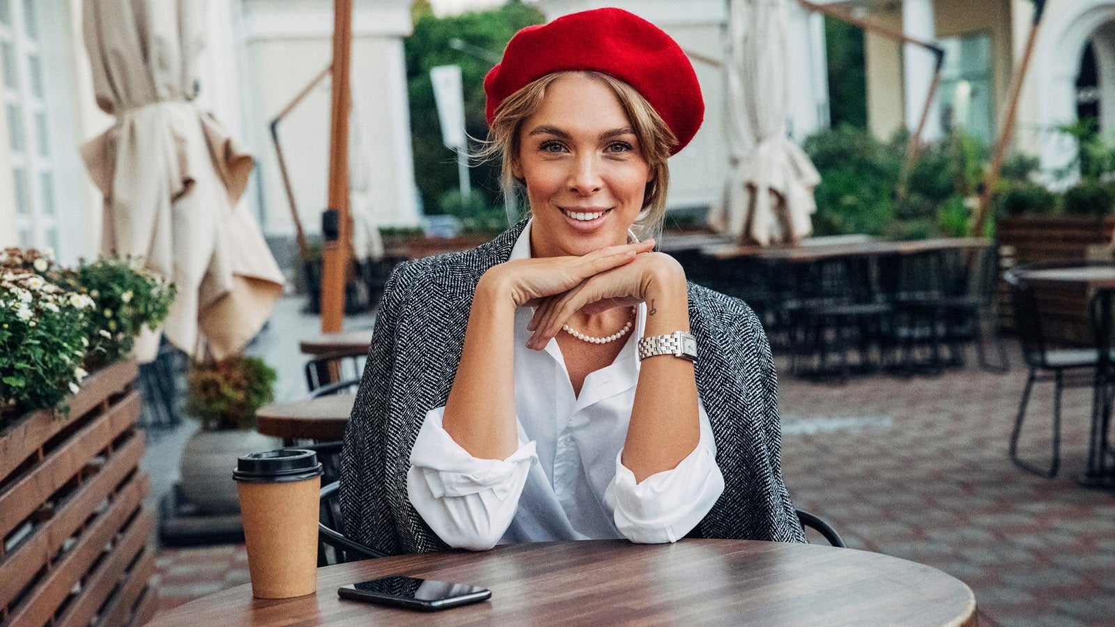 Beautiful woman wearing red beret drinking coffee