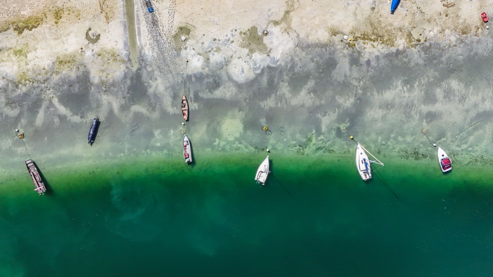 12.09.2026, Baden-W&uuml;rttemberg, Moos: Bei sonnigem Sp&auml;tsommerwetter am Bodensee liegen einige Boote aufgrund des niedrigen Wasserstands auf dem Trockenen. Foto: Marius Bulling/onw-images/dpa