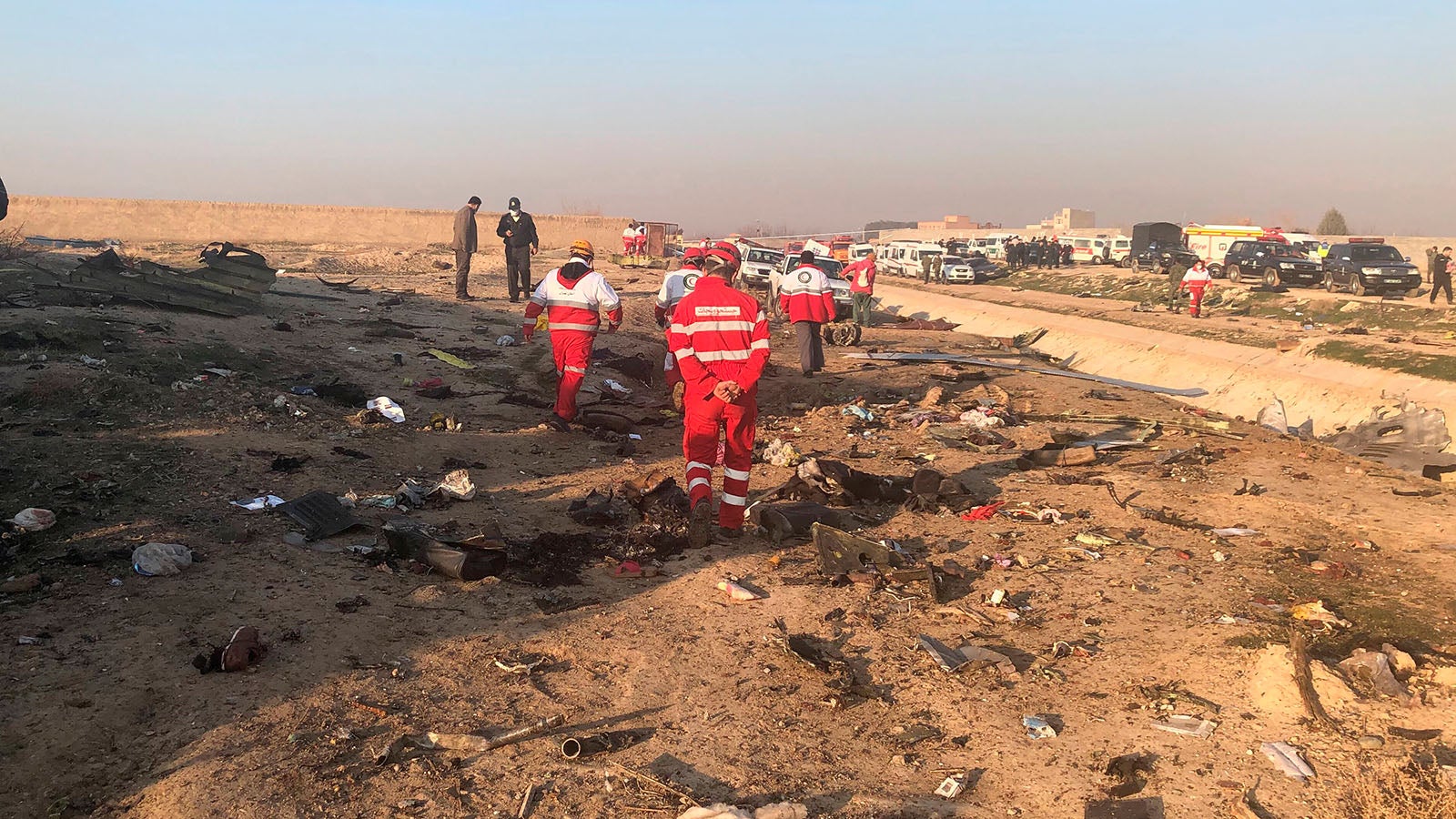 dpatopbilder - 08.01.2020, Iran, Tehran: Rettungskr&auml;fte stehen am Ort eines Flugzeugabsturzes am Rande von Teheran. Bei dem Absturz der ukrainischen Passagiermaschine nahe Teheran sind nach Angaben der Hilfsorganisation iranischer Halbmond alle Insassen ums Leben gekommen. Foto: Mohammad Nasiri/AP/dpa +++ dpa-Bildfunk +++