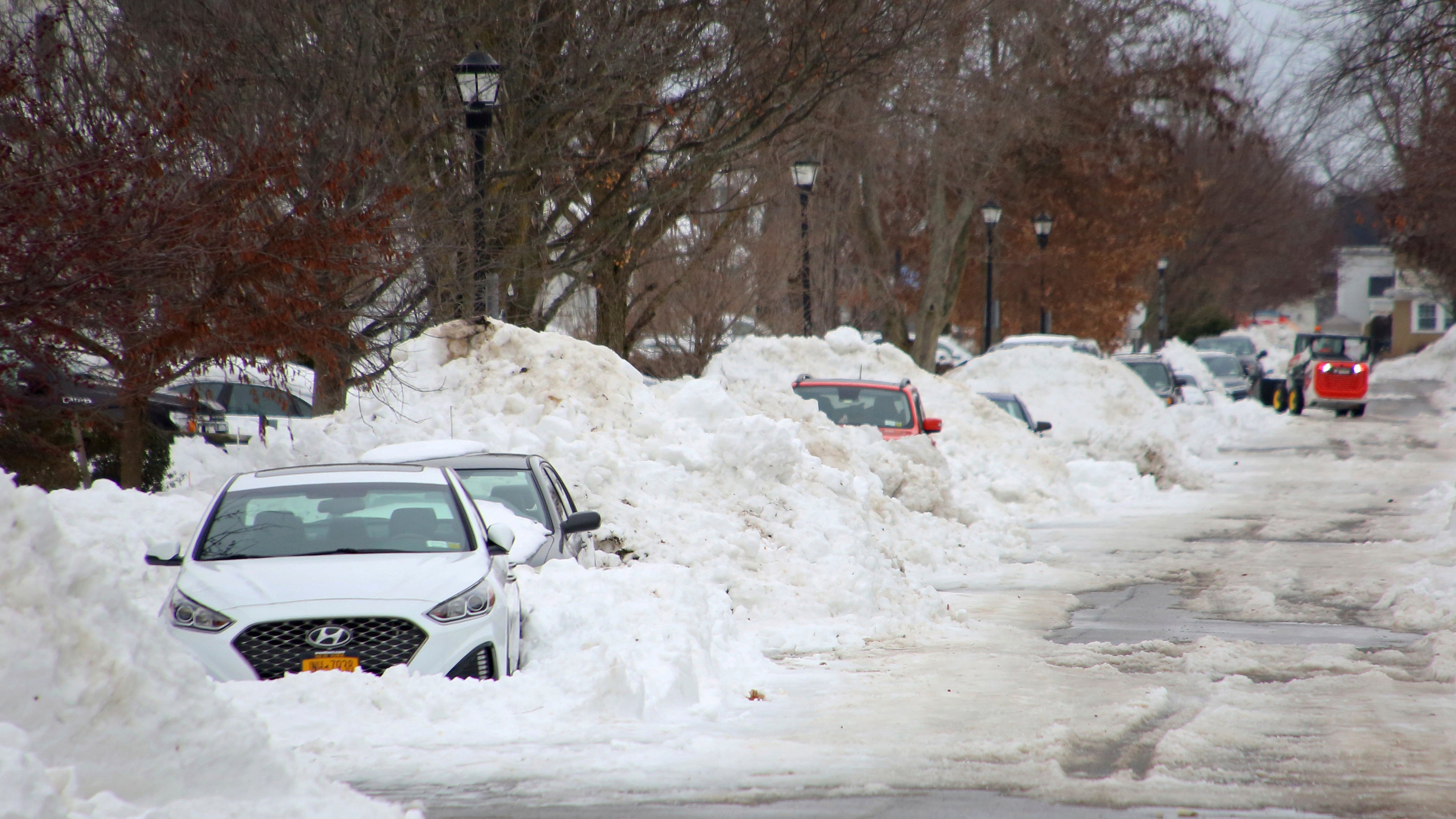 Wenige Tage nach dem verheerenden Blizzard, stehen schneebedeckte Autos am Stra&szlig;enrand von Buffalo