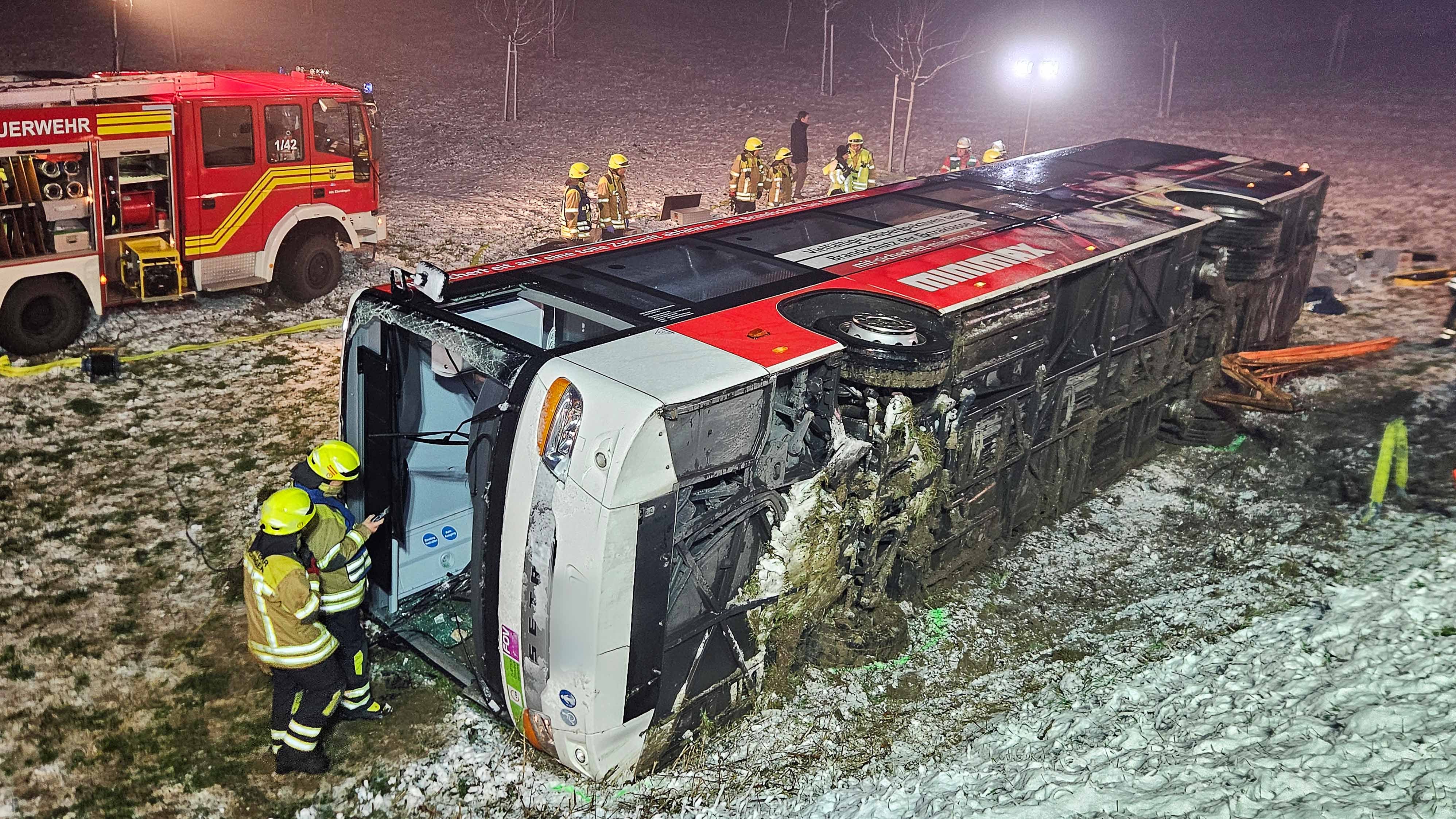 dpatopbilder - 02.01.2025, Baden-W&cedil;rttemberg, Hemmingen: Einsatzkr&permil;fte der Feuerwehr stehen neben einem umgekippten Linienbus an der Unfallstelle im Landkreis Ludwigsburg. Mehrere Menschen sind nach ersten Erkenntnissen beim Unfall des Linienbusses verletzt worden. Eines der Opfer wurde eingeklemmt, wie ein Sprecher der Polizei mitteilte. Foto: Andreas Rosar/dpa - ACHTUNG: Kennzeichen wurde(n) aus rechtlichen Gr&cedil;nden gepixelt +++ dpa-Bildfunk +++