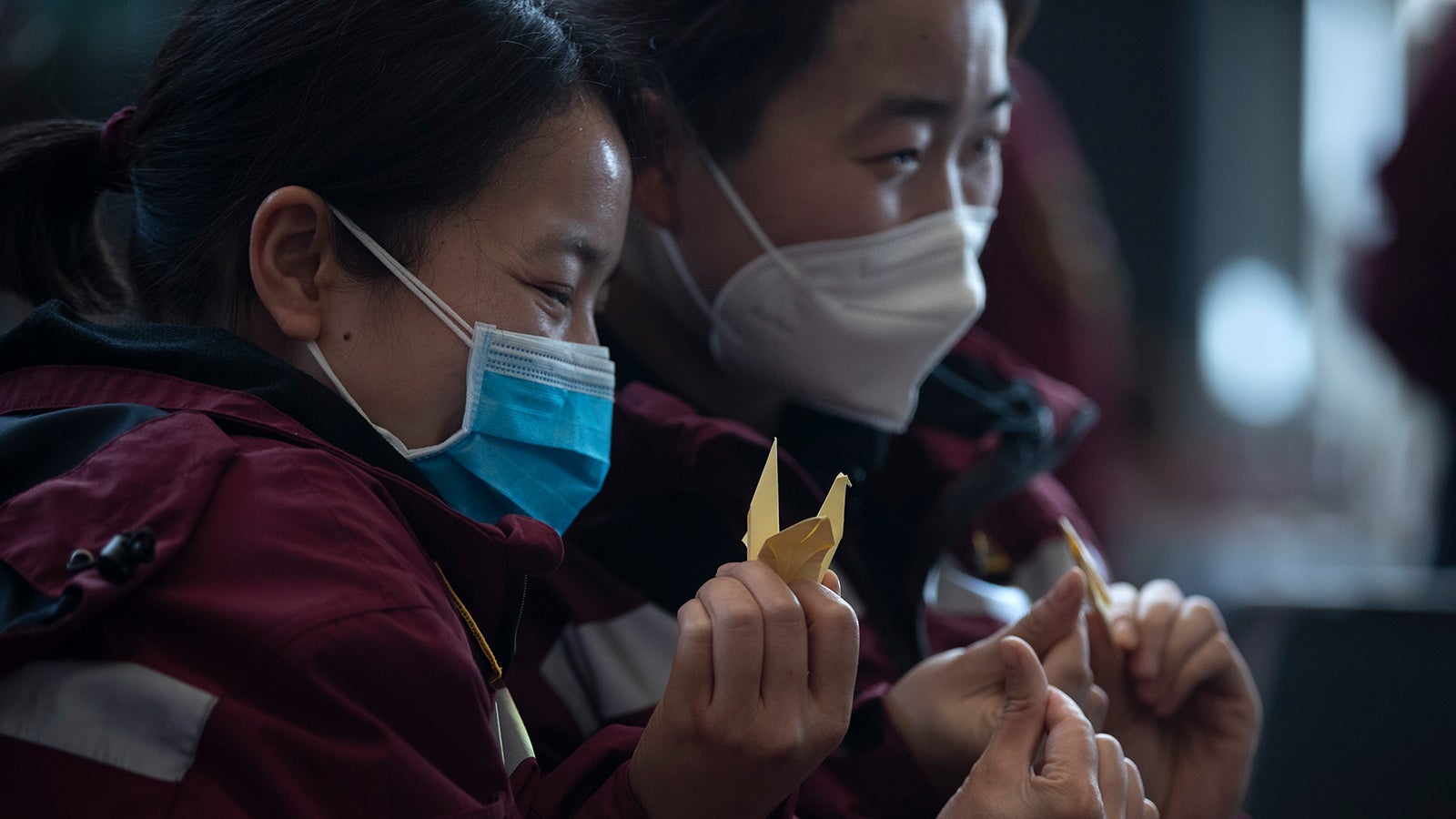 17.03.2020, China, Wuhan: Zwei medizinischen Mitarbeiterinnen falten Papierflieger. Einige der medizinischen Helfer haben begonnen, die Provinz Hubei zu verlassen, da die Covid-19-Neuerkrankungen zur&uuml;ckgehen. Foto: Fei Maohua/XinHua/dpa +++ dpa-Bildfunk +++