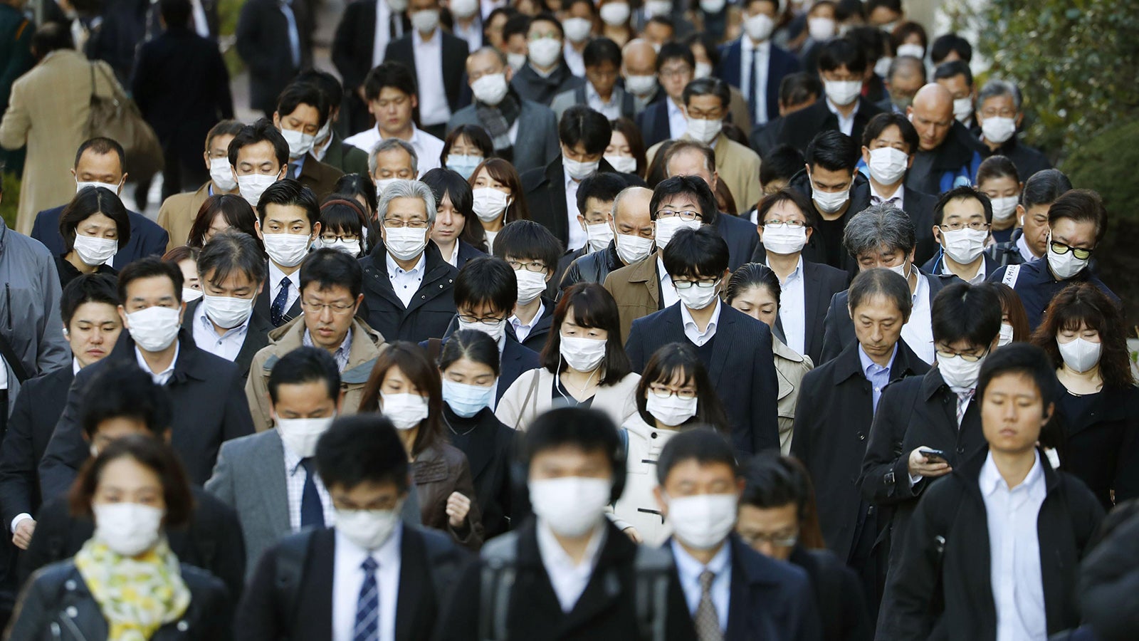 Tokio: Passanten tragen Masken und gehen dicht aneinander gedr&auml;ngt &uuml;ber eine Stra&szlig;e. Japan will trotz der Einstufung des Coronavirus als Pandemie wie geplant die Olympischen Spiele im Sommer ausrichten. Foto: -/kyodo/dpa 