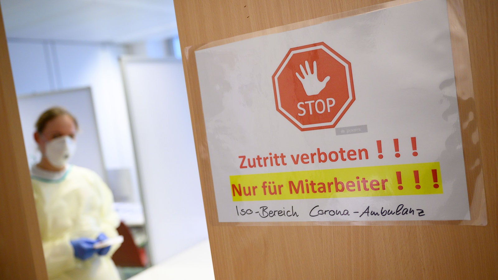 04.03.2020, Baden-W&uuml;rttemberg, Stuttgart: Eine freiwillige Mitarbeiterin des Deutschen Roten Kreuzes (DRK) steht in der Corona-Ambulanz des Klinikums Stuttgart im Katharinenhospital hinter einem Hinweis, auf dem "Zutritt verboten!!! Nur f&uuml;r Mitarbeiter!!! Iso-Bereich Corona-Ambulanz" steht. In der Corona-Ambulanz k&ouml;nnen sich Patienten testen lassen. Foto: Sebastian Gollnow/dpa +++ dpa-Bildfunk +++ Das neuartige Coronavirus Sars-CoV-2, das Covid-19 ausl&ouml;st, ist noch wenig erforscht. Die WHO gab jetzt Unterschiede zur Influenza bekannt.