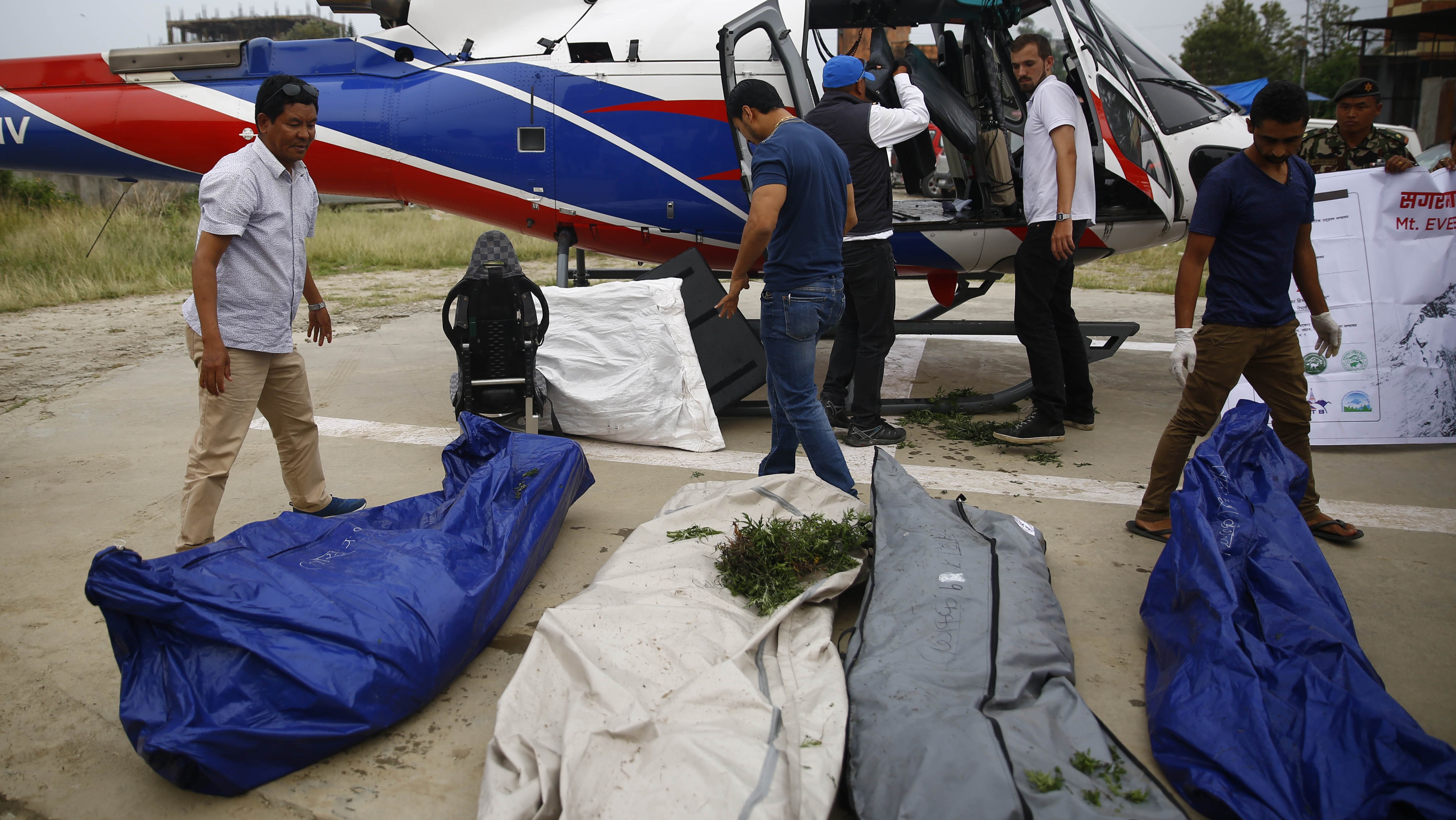 Ein Team der Nepal Army l&auml;dt die sterblichen &Uuml;berreste von vier Bergsteigern aus einen Hubschrauber.