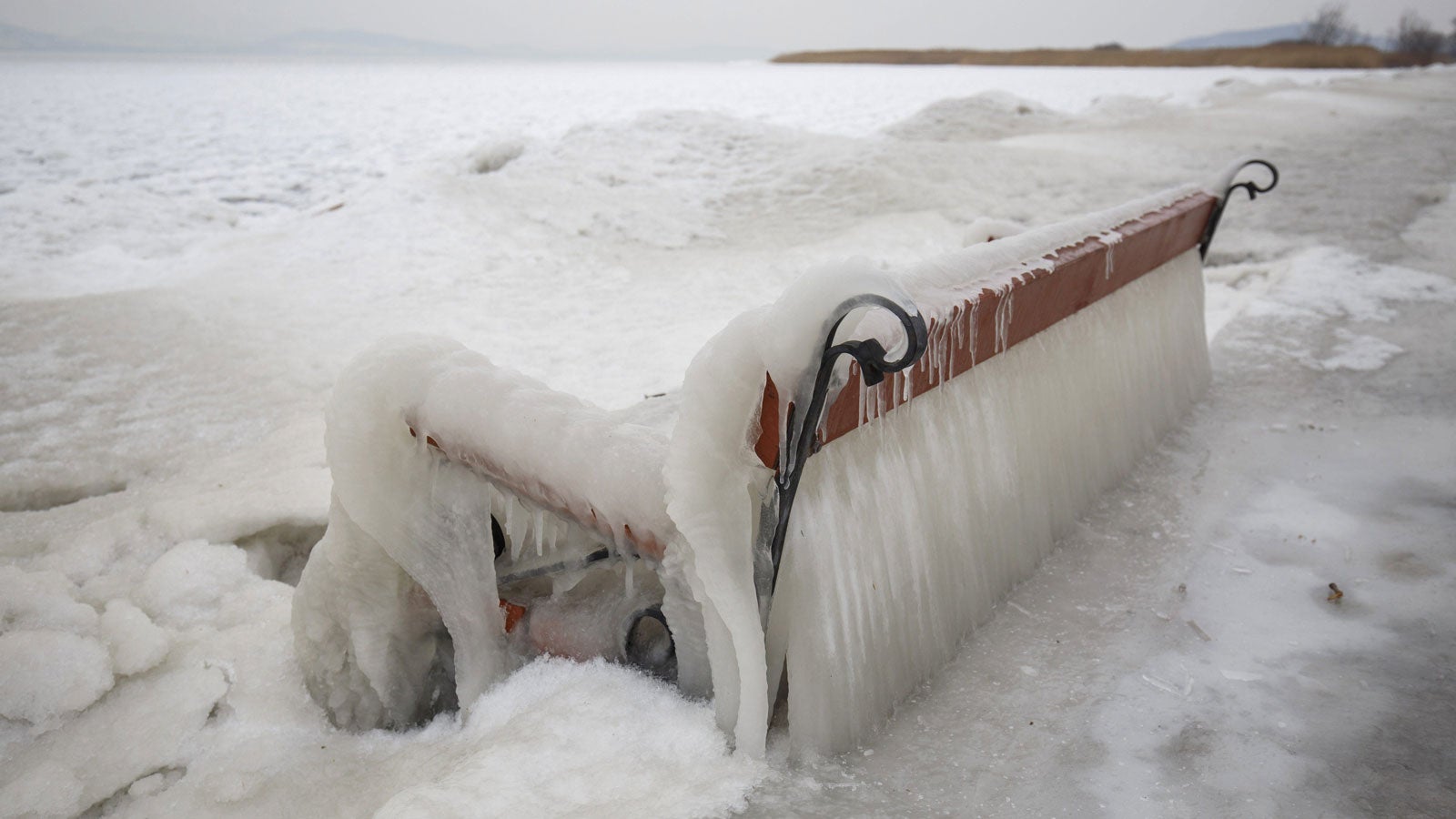 26.02.2018, Ungarn, Balatonfenyves: Eine komplett vereiste Bank steht am Ufer des Balaton. Foto: Gyorgy Varga/MTI/dpa