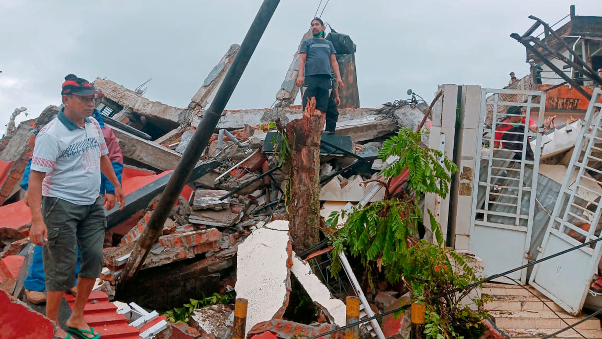 Indonesien, Mamuju: Anwohner inspizieren besch&auml;digte H&auml;user. Bei einem Erdbeben der St&auml;rke 6,2 sind auf der indonesischen Insel Sulawesi mehrerei Menschen ums Leben gekommen.