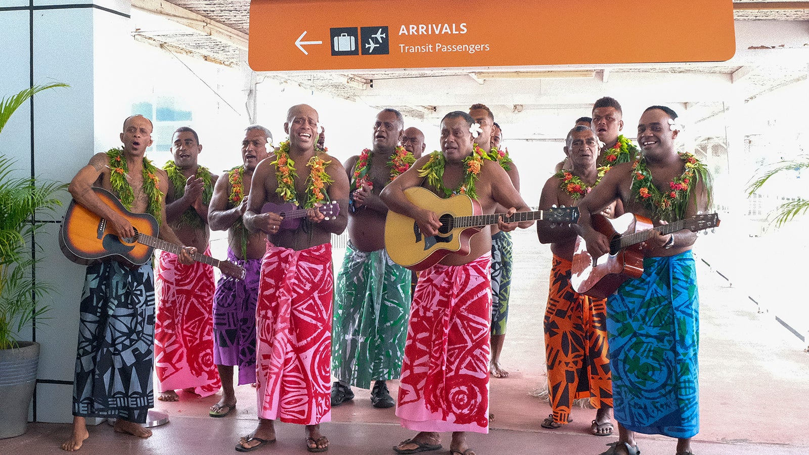 In this photo released by Tourism Fiji, guests receive a traditional Fijian welcome as they arrive at Nadi International airport in Fiji, Wednesday, Dec. 1, 2021. Fiji welcomed back its first tourists in more than 600 days on Wednesday after deciding to push ahead with reopening plans despite the threat posed by the omicron variant. (Bruce Rounds/Tourism Fiji via AP)