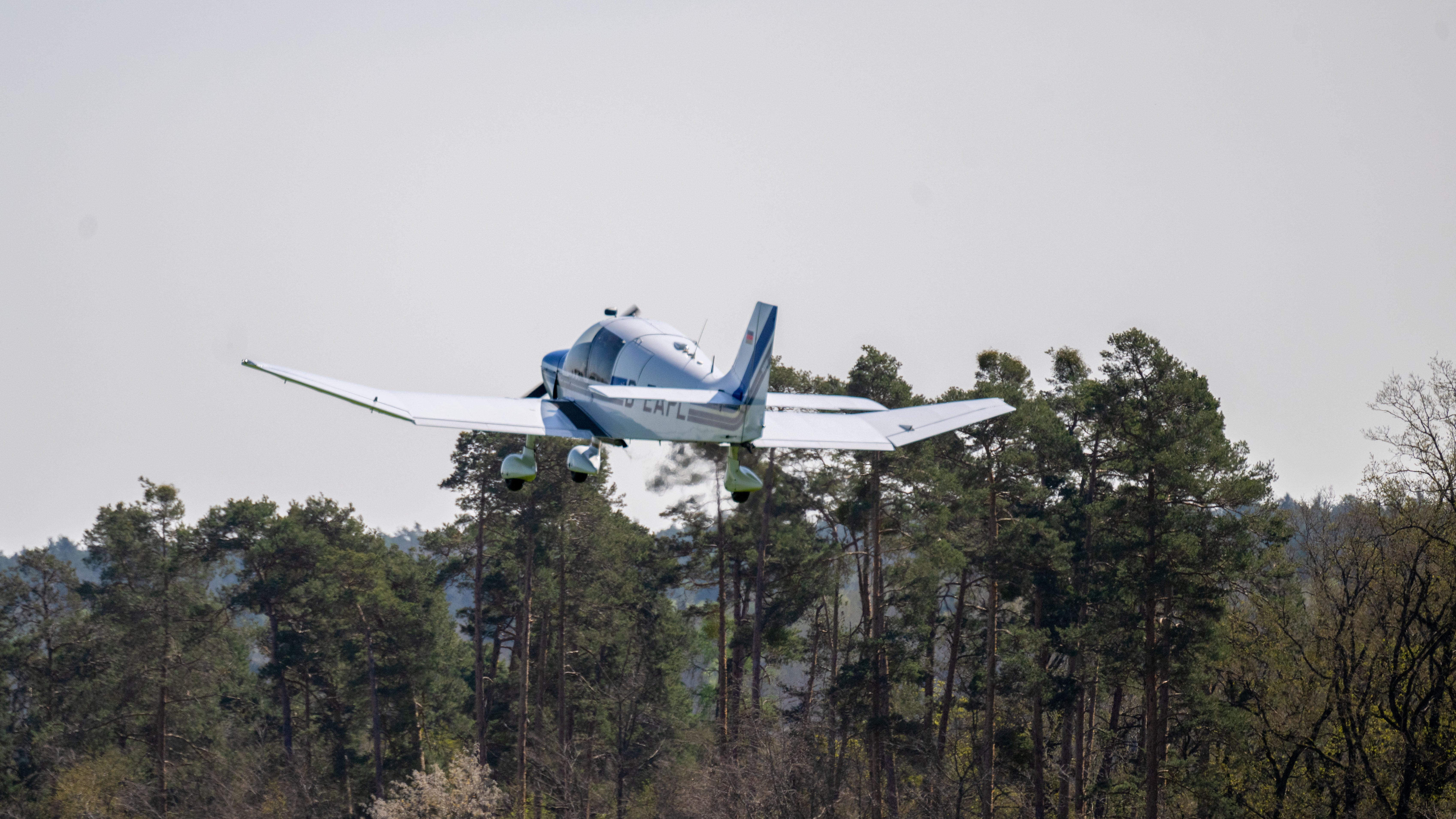 12.04.2024, Bayern, Flugplatz Ansbach-Petersdorf: Ein Motorflugzeug fliegt &uuml;ber B&auml;umen. Am Flugplatz Ansbach-Petersdorf bereiten sich die ehrenamtlichen Luftbeobachter und Piloten der Luftrettungsstaffel Bayern zusammen mit der Integrierten Leitstelle auf die anstehende Saison vor (Pia Bayer/dpa)
