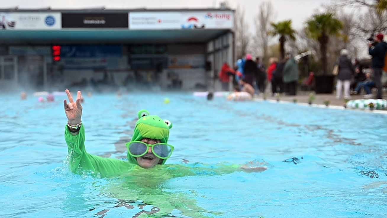 14.03.2025, Baden-W&cedil;rttemberg, Karlsruhe: Ein Badegast in einem Froschkost&cedil;m schwimmt im Freibad. Das Sonnenbad Karlsruhe startet als eines der ersten Freib&permil;der Deutschlands in die neue Badesaison - unter dem Motto &acute;Karlsruhe geht Baden!&ordf; Foto: Markus Lenhardt/dpa +++ dpa-Bildfunk +++