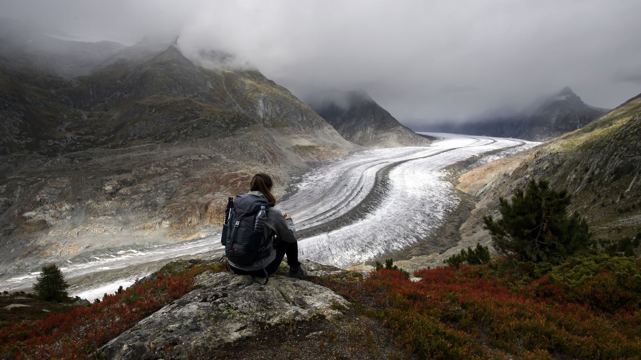 27.09.2023, Schweiz, Bettmeralp: Eine Wanderin blickt an einem Herbsttag auf den Schweizer Aletschgletscher oberhalb der Bettmeralp im Wallis, Schweiz. (Anthony Anex/KEYSTONE/dpa)
