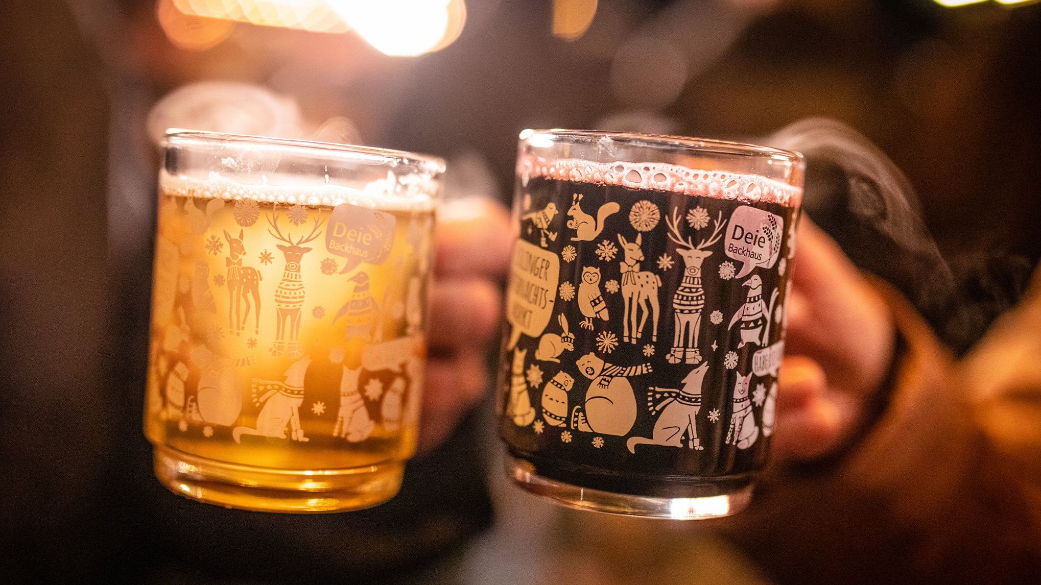 25.11.2023, Baden-W&uuml;rttemberg, Esslingen am Neckar: Ein P&auml;rchen st&ouml;&szlig;t auf dem Esslinger Weihnachtsmarkt mit wei&szlig;em und rotem Gl&uuml;hwein an. (Christoph Schmidt/dpa)