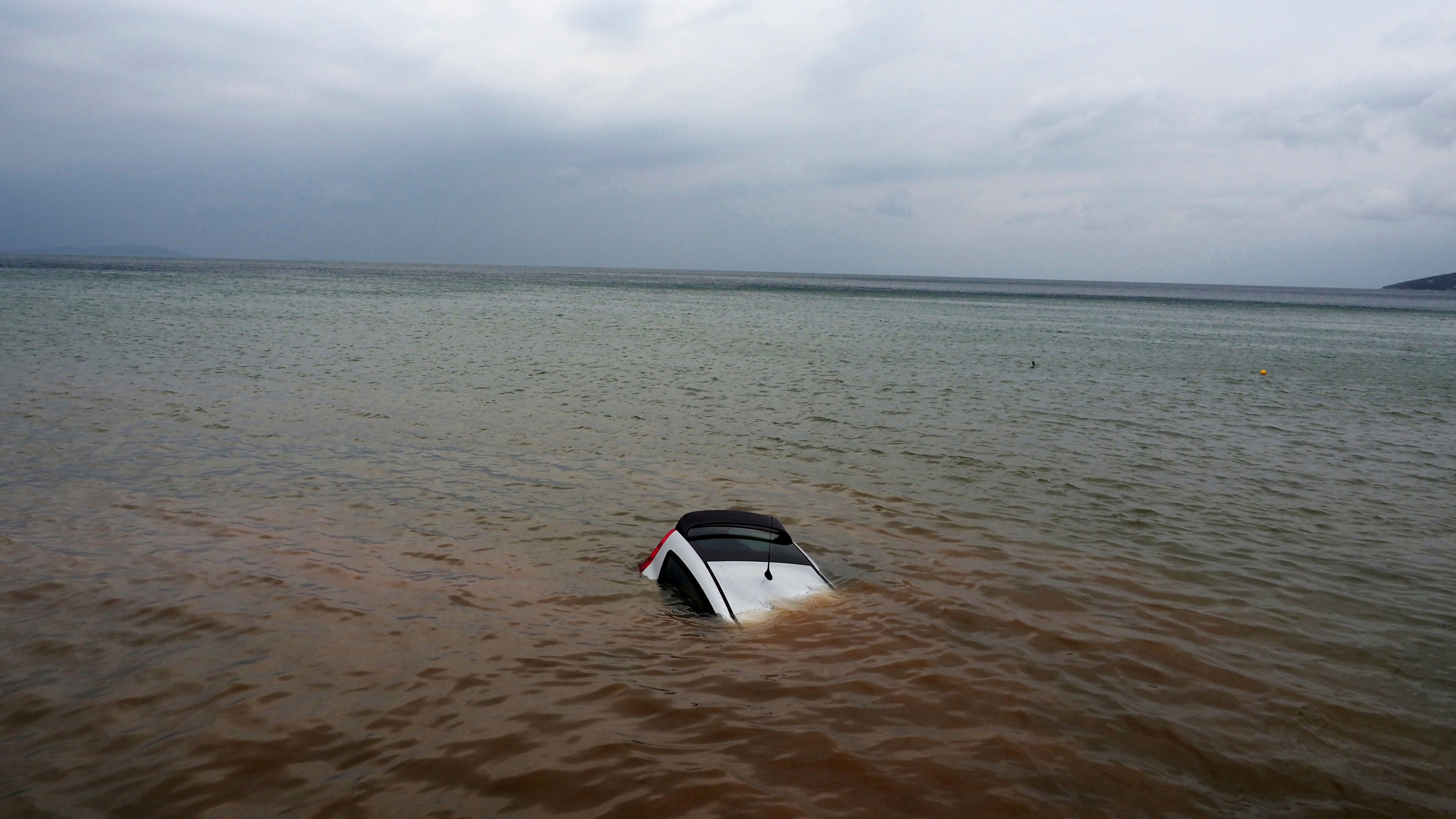 06. September 2023: Im Dorf Milina in der Region Pilion in Mittelgriechenland ist ein Auto zu sehen, das infolge der heftigen Regenf&auml;lle halb im Meer versunken ist. (AP)