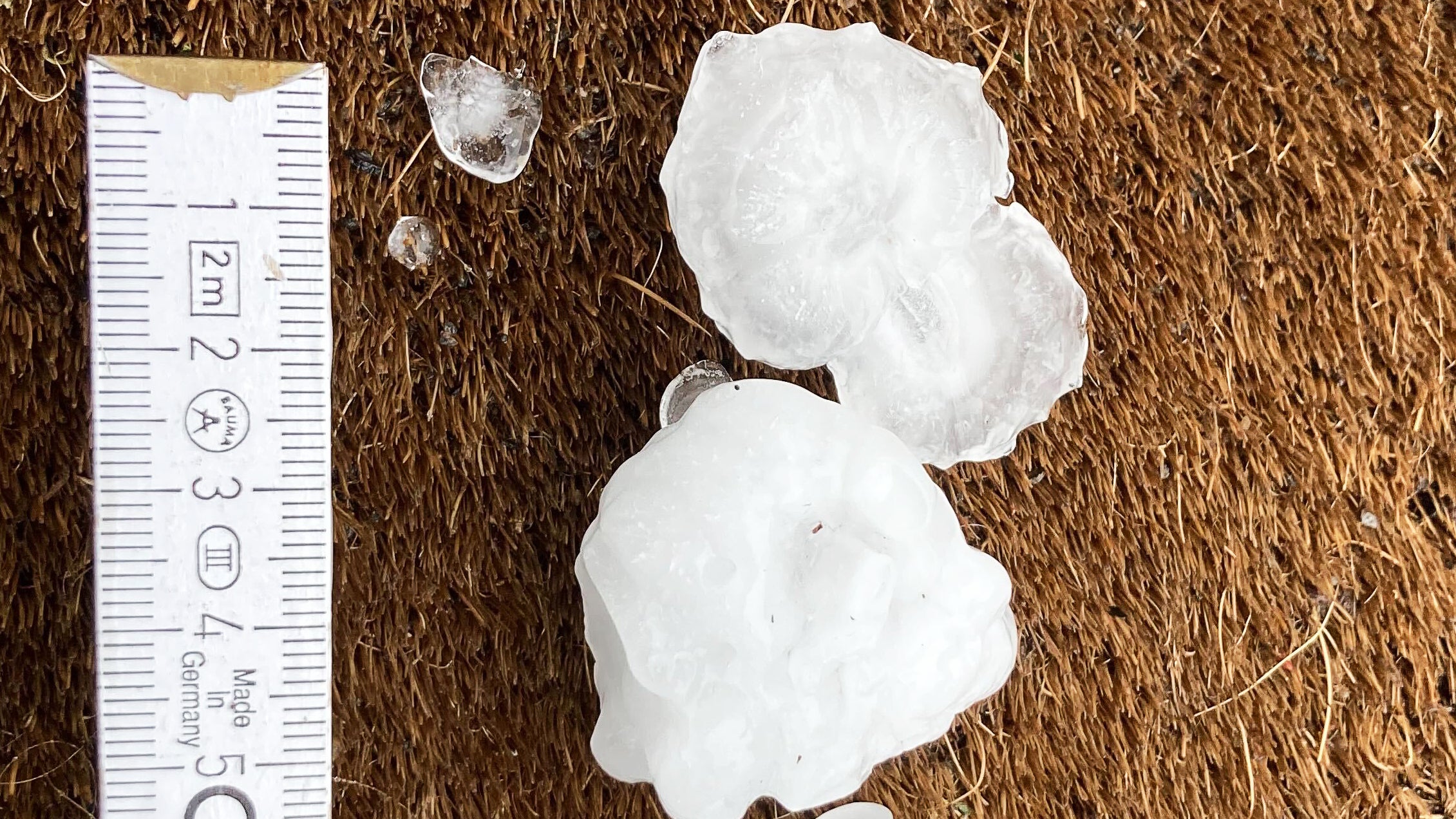 28.04.2023, Rheinland-Pfalz, Mainz: Gro&szlig;e Hagelk&ouml;rner liegen nach einem Unwetter in einem Vorgarten im Stadtteil Ebersheim. Bei wechselhaftem Wetter und einzelnen Gewittern in Rheinland-Pfalz k&ouml;nnen laut Deutschem Wetterdienst (DWD) starke bis st&uuml;rmische B&ouml;en aufziehen. Foto: Jan Brinkhus/dpa +++ dpa-Bildfunk +++