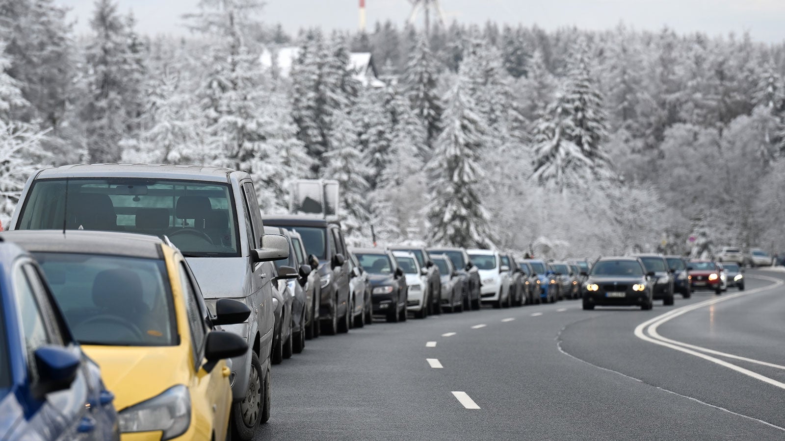 02.01.2021, Niedersachsen, Torfhaus: Fahrzeuge stehen auf Behelfsparkpl&auml;tzen an der Bundesstra&szlig;e 242 zwischen Braunlage und Torfhaus im Harz. Foto: Swen Pf&ouml;rtner/dpa +++ dpa-Bildfunk +++