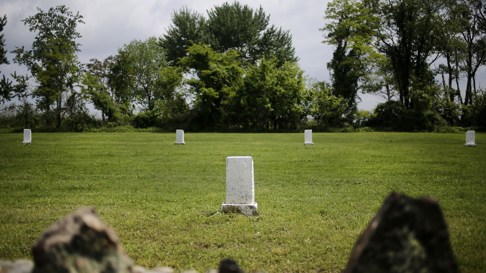 FILE - In this May 23, 2018 file photo, white markers, each indicating a mass grave of 150 people, are displayed on Hart Island in New York. New York City officials are considering a plan to turn the island where the poor and homeless have been buried for 150 years into a park. About one million people have been buried on Hart Island since 1869. (AP Photo/Seth Wenig, File) 
Credit: AP 