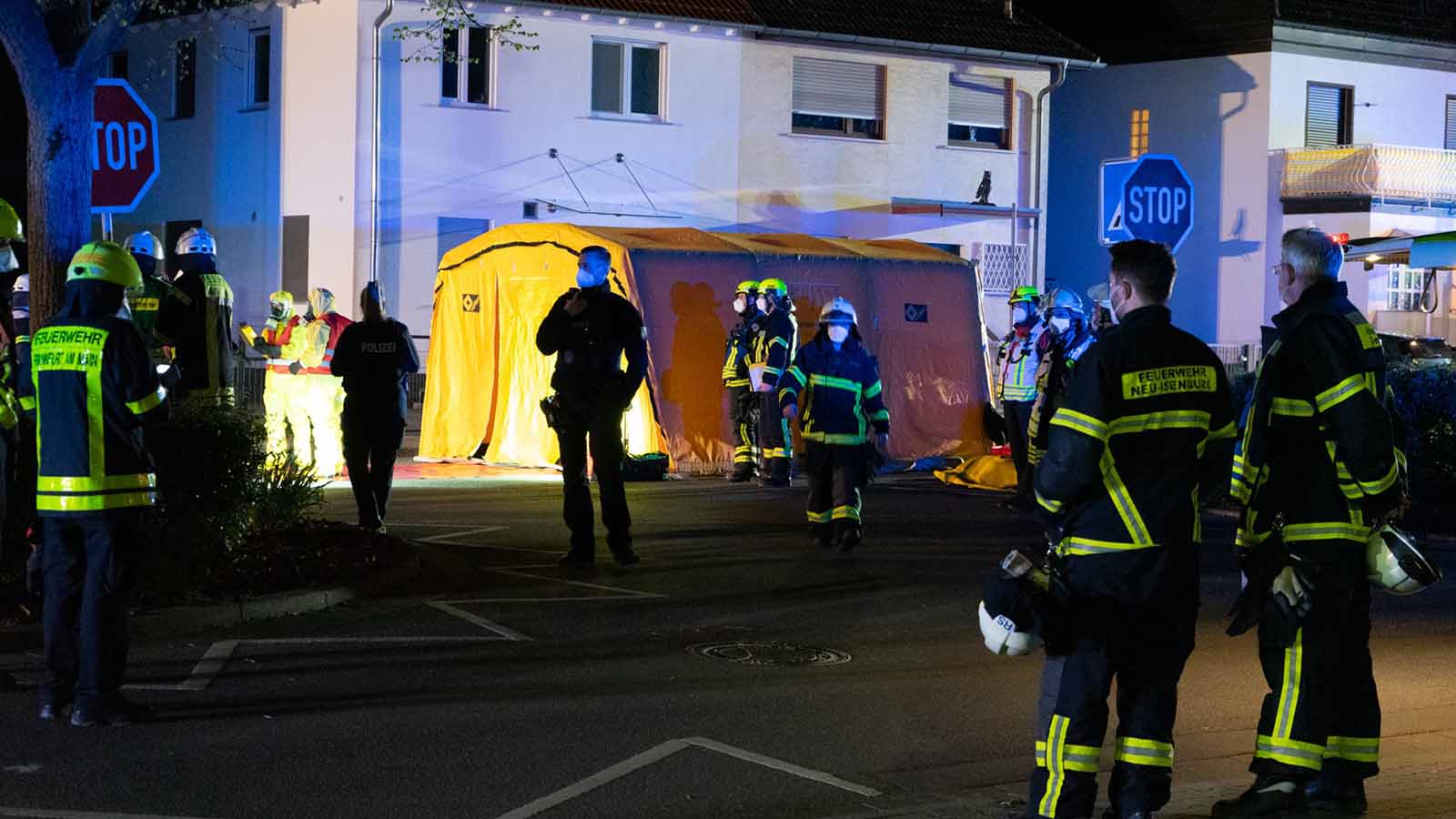 26.04.2021, Hessen, Neu-Isenburg: Feuerwehrkr&auml;fte stehen auf einer abgesperrten Stra&szlig;e vor einem aufgebauten Zelt. Beim Aufr&auml;umen einer Garage hat ein Mann in Neu-Isenburg (Landkreis Offenbach) einen Beh&auml;lter mit radioaktivem Material gefunden und einen Gro&szlig;einsatz der Feuerwehr ausgel&ouml;st. (zu dpa: &laquo;Mann findet radioaktives Material in Garage&raquo;) Foto: -/5vision.media/dpa +++ dpa-Bildfunk +++