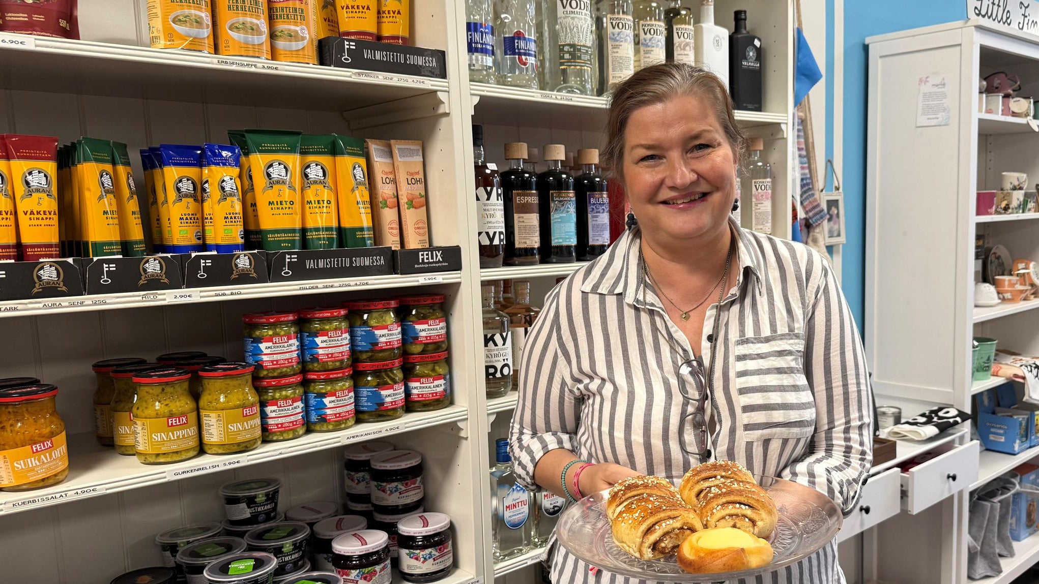 24.07.2025, Hessen, Hanau: Die geb&uuml;rtige Finnin Annika Borisov zeigt in ihrem Laden "Little Finland" ein Tablett mit frisch gebackenen finnischen Korvapuusti (Zimtschnecken). (Michael Bauer/dpa)