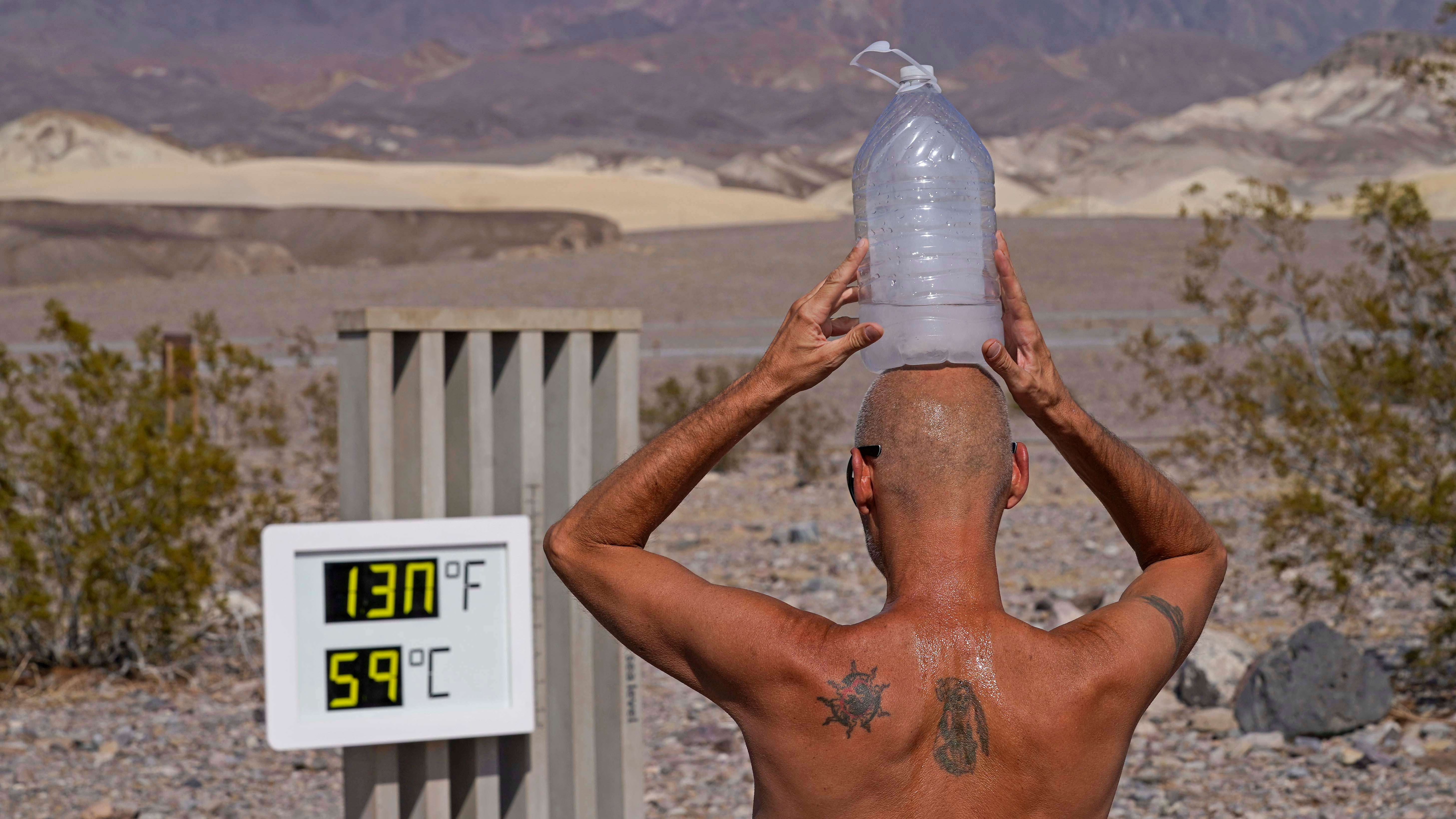 ARCHIV - 18.08.2020, USA, Death Valley National Park: Steve Krofchik k&cedil;hlt sich im &acute;Death Valley&ordf;-Nationalpark mit einer mit Eiswasser gef&cedil;llten Plastikflasche auf dem Kopf ab. (zu dpa: &acute;Es geht noch heiﬂer - Kennen Sie diese Temperaturrekorde?&ordf;) Foto: John Locher/AP/dpa +++ dpa-Bildfunk +++