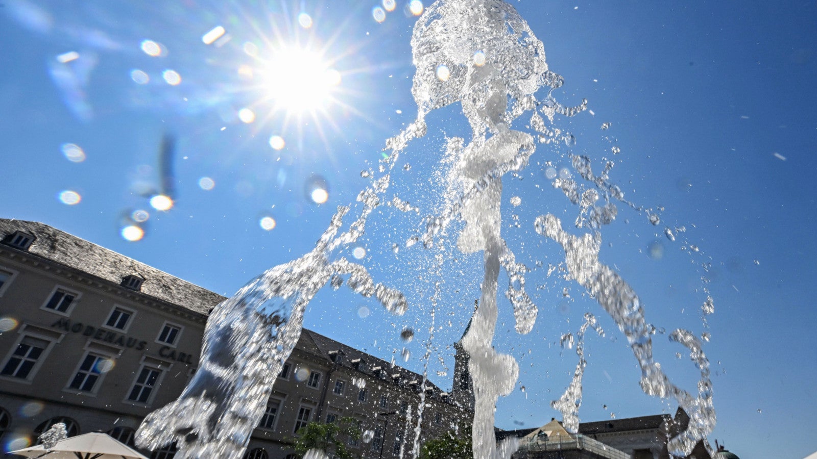 Bei hochsommerlichen Temperaturen sprudelt aus einem Brunnen am Marktplatz Wasser in die H&ouml;he. Foto: Uli Deck/dpa