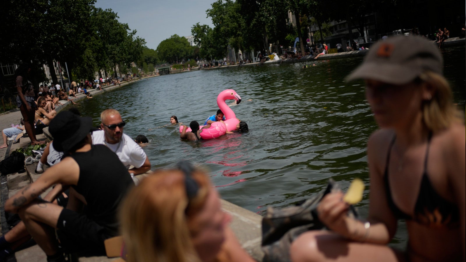 23.06.2026, Frankreich, Paris: Pariser baden im Canal Saint-Martin. Foto: Christophe Ena/AP/dpa