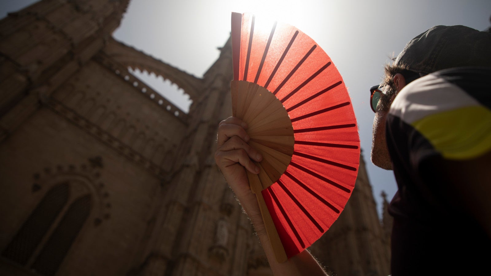22.06.2026, Spanien, Palma: Eine Frau k&uuml;hlt sich mit einem F&auml;cher ab. Die Insel erlebt derzeit sehr hohe Temperaturen. Foto: Clara Margais/dpa