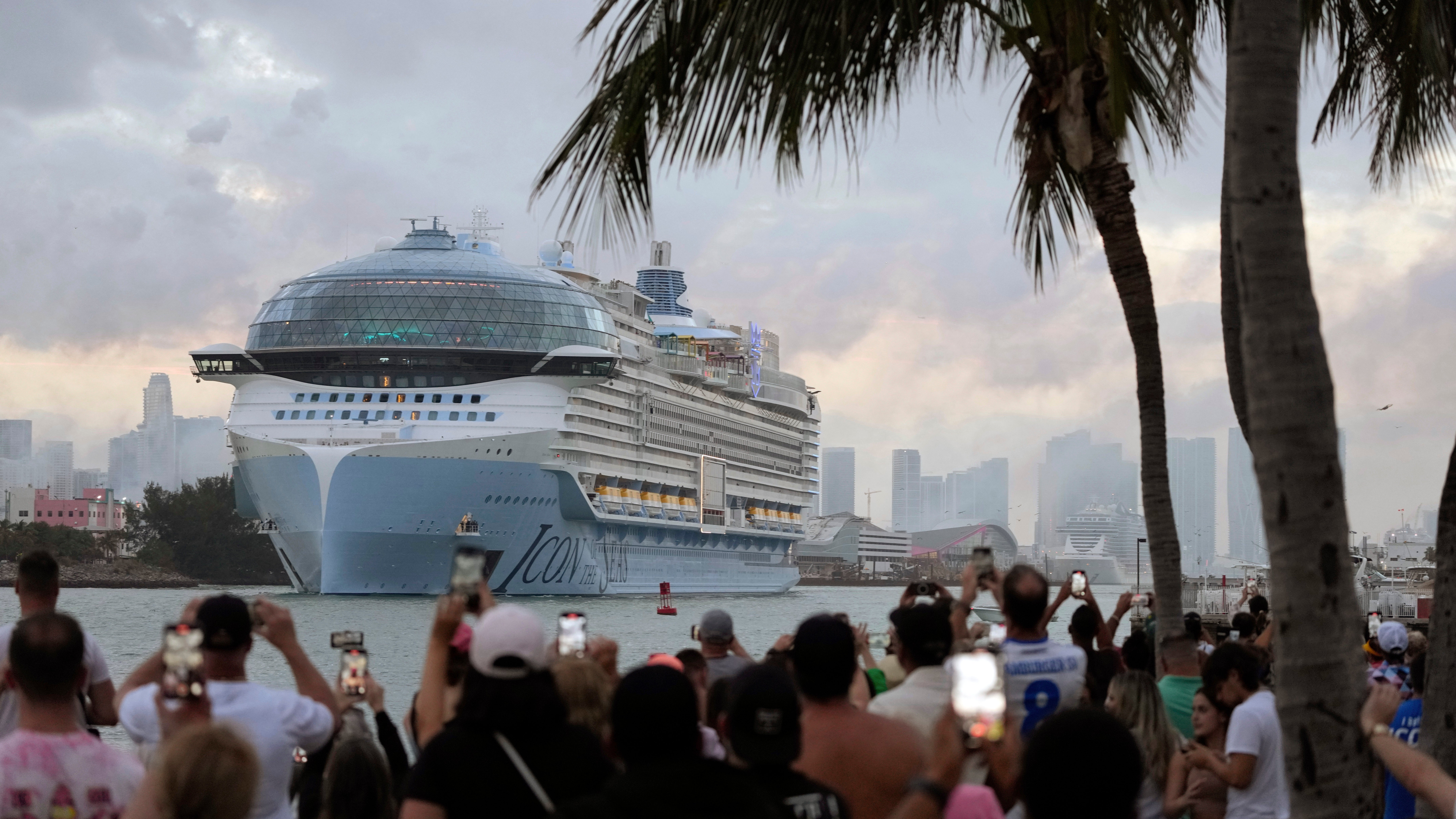 27.01.2024, USA, Miami Beach: Menschen filmen vom South Pointe Park aus, wie die Icon of the Seas, das gr&ouml;&szlig;te Kreuzfahrtschiff der Welt, auf seiner ersten &ouml;ffentlichen Kreuzfahrt aus PortMiami herausf&auml;hrt. (Rebecca Blackwell/AP)

