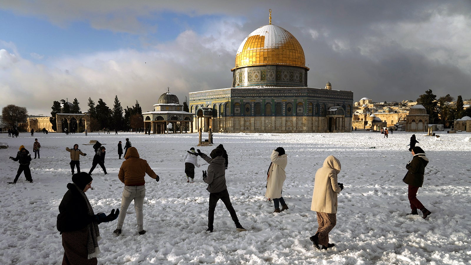 Palestinians enjoy the snow next to the Dome of the Rock Mosque in the Al Aqsa Mosque compound in Jerusalem Old city, Thursday, Jan. 27, 2022. A rare snowfall hit parts of Israel and the West Bank, closing schools and businesses. (AP Photo/Mahmoud Illean)
