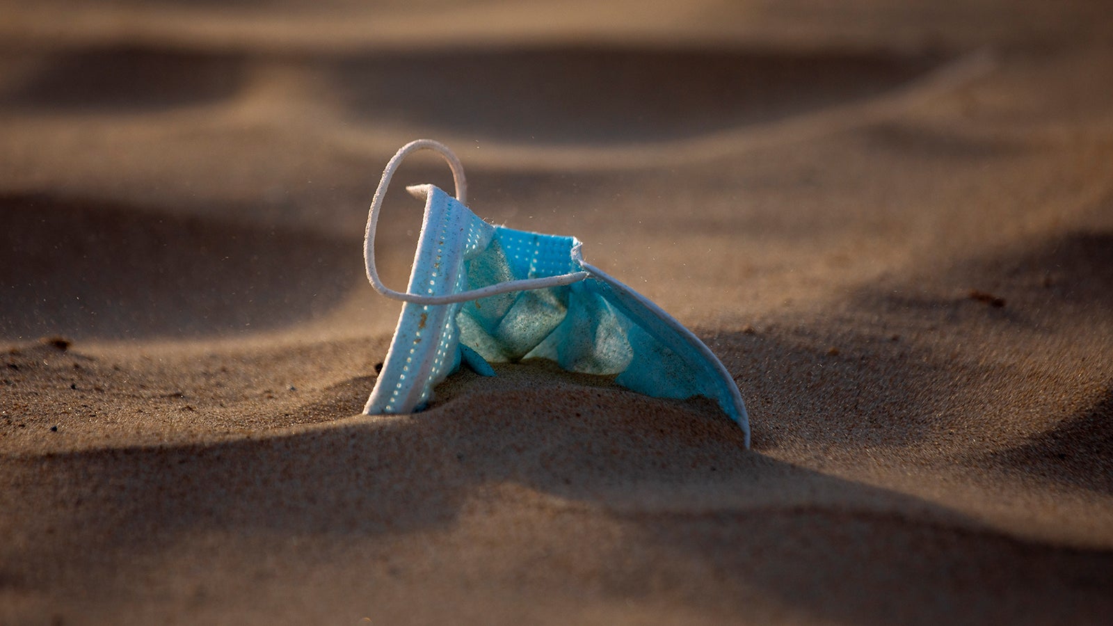 Eine Gesichtsmaske liegt am Strand von Tel Aviv. Wegen der sengenden Hitze im Land haben Beh&ouml;rden die Auflange f&uuml;r die Maskenpflicht gelockert. Foto: AP Photo/Oded Balilty