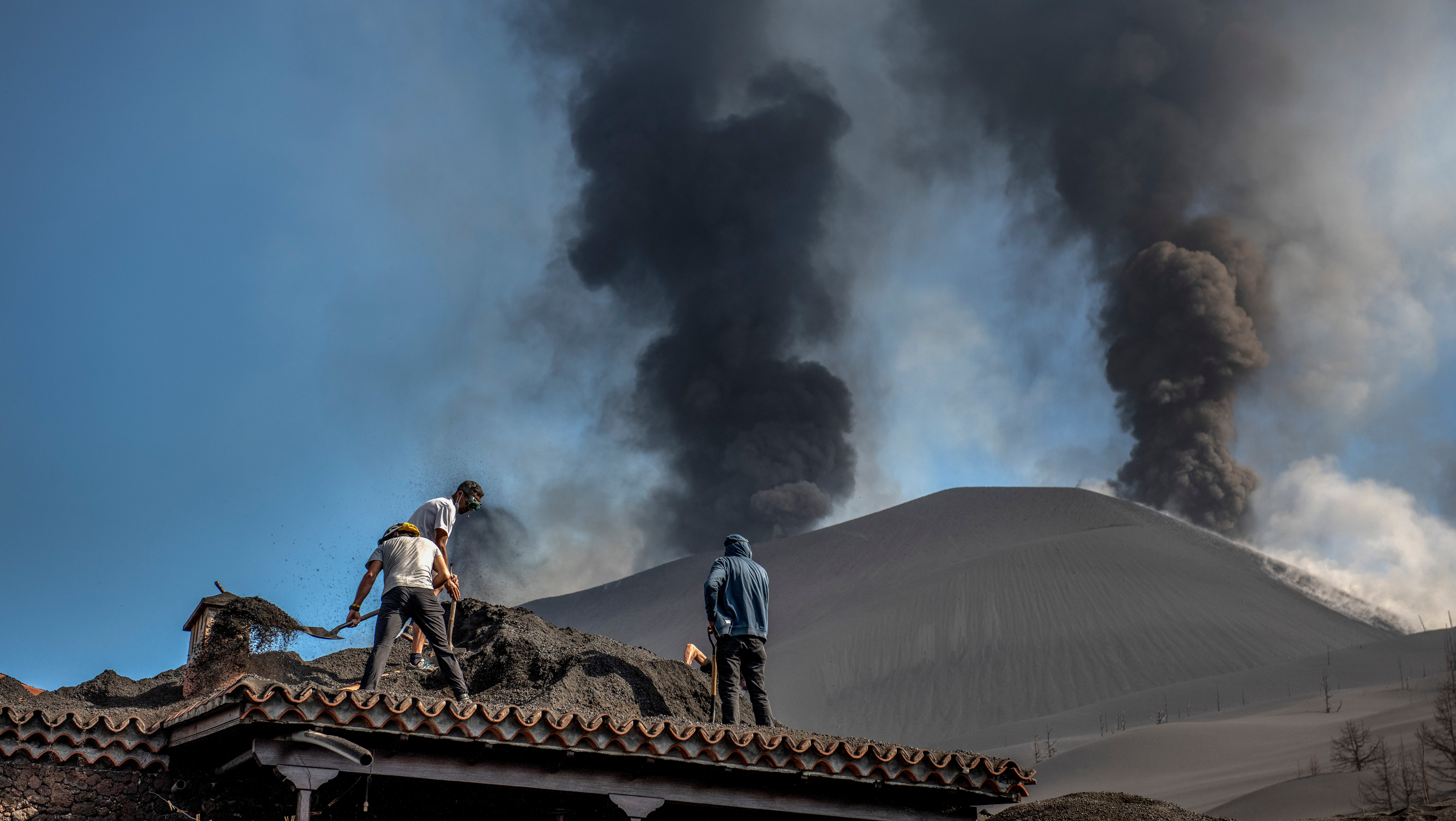 Spanien, La Palma: Menschen s&auml;ubern ein Haus von der Asche des Vulkans in Las Manchas auf der Kanareninsel La Palma. Wegen n&auml;herr&uuml;ckender Lava haben die Beh&ouml;rden auf der Vulkaninsel La Palma am Donnerstag die Evakuierung von etwa 300 Menschen angeordnet.