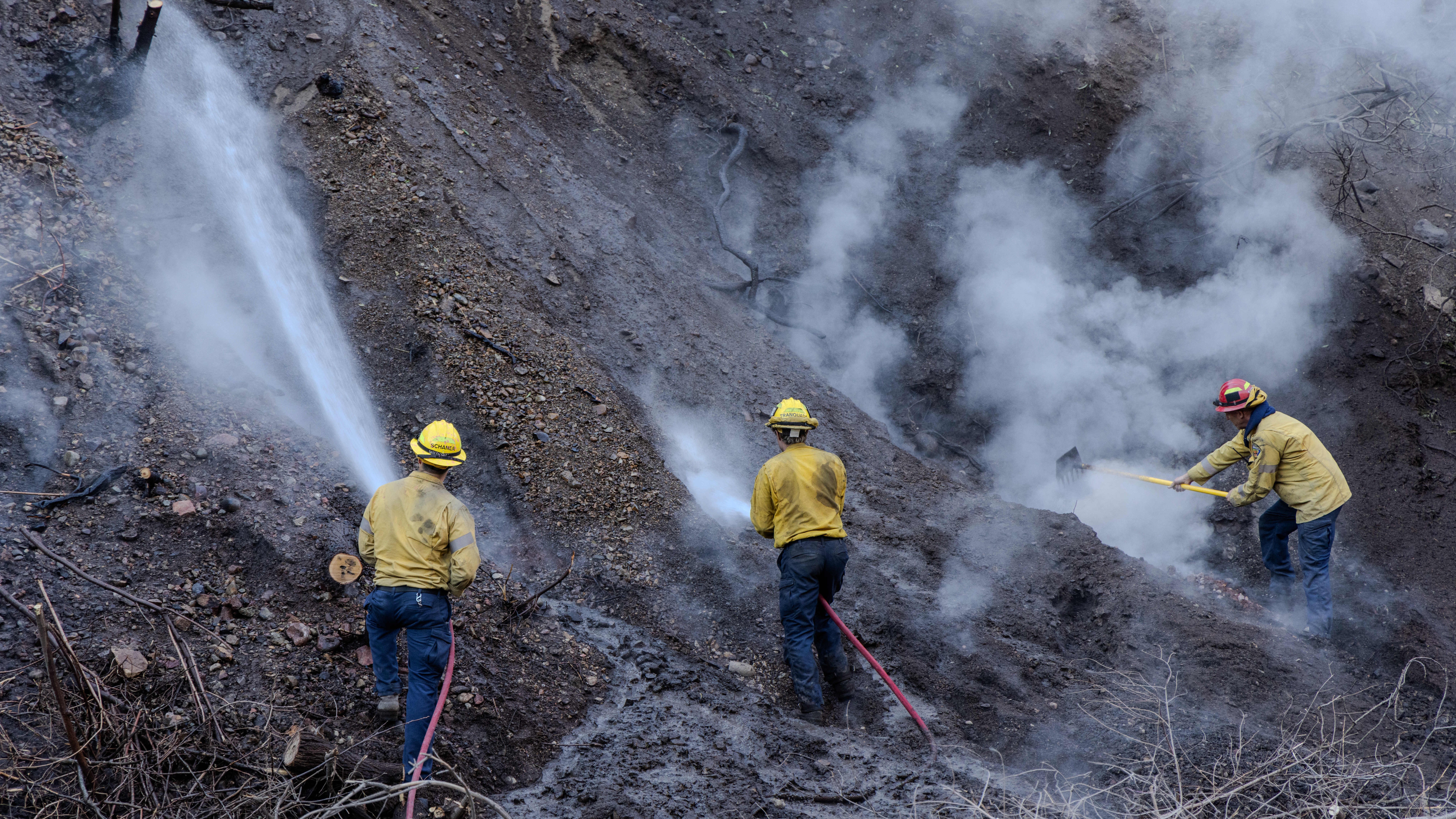16.01.2025, USA, Pazifik Palisaden: Feuerwehrleute besprengen hei&szlig;es Erdreich mit Wasser. Das Palisades-Feuer ist erst zu 20 Prozent einged&auml;mmt. An vielen Stellen ist der Boden noch sehr hei&szlig;. (Amy Katz/ZUMA Press Wire/dpa)
