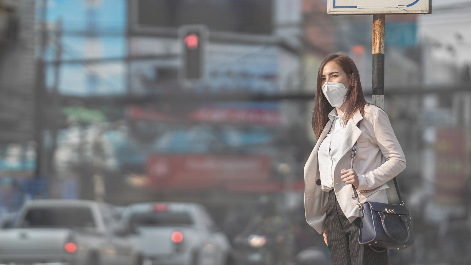 Asian woman are going to work.she wears N95 mask.Prevent PM2.5 dust and smog