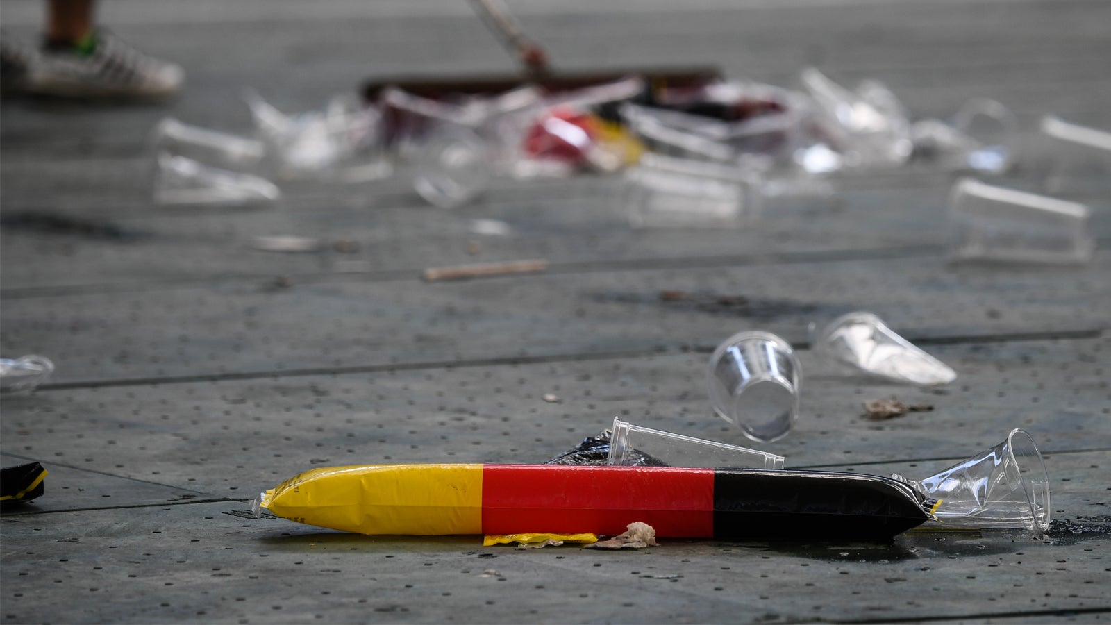 27.06.2018, Hessen, Frankfurt am Main: Reinigungskr&auml;fte kehren den Bereich des Public Viewings der Fussball-WM in der Commerzbank-Arena nach dem Spiel sauber. Fans haben Becher und Fahnen hinterlassen. Foto: Andreas Arnold/dpa +++ dpa-Bildfunk +++