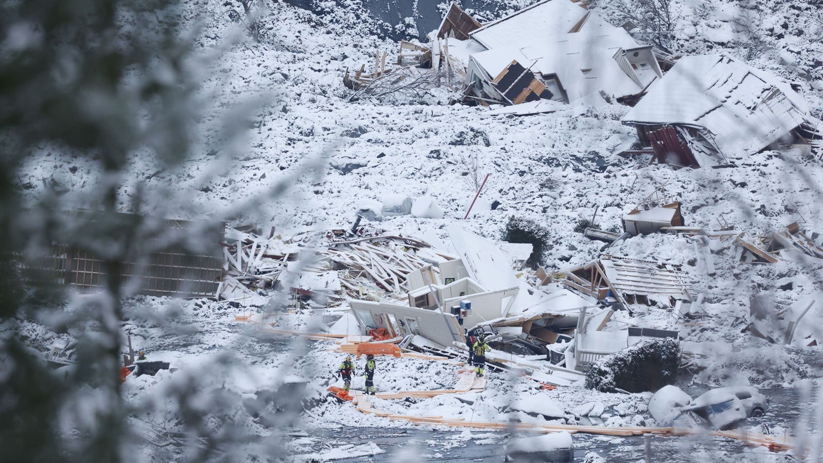 02.01.2021, Norwegen, Ask: Rettungsmannschaften sind nach einem Erdrutsch zwischen zerst&ouml;rten Geb&auml;uden im Einsatz. Drei Tage nach dem Erdrutsch haben die Rettungskr&auml;fte eine zweite Leiche im Ungl&uuml;cksgebiet gefunden. Damit sind bislang zwei Opfer im Erdrutschgebiet entdeckt worden. Mehrere Menschen werden weiter vermisst. Foto: Tor Erik Schroeder/ntb/AP/dpa +++ dpa-Bildfunk +++