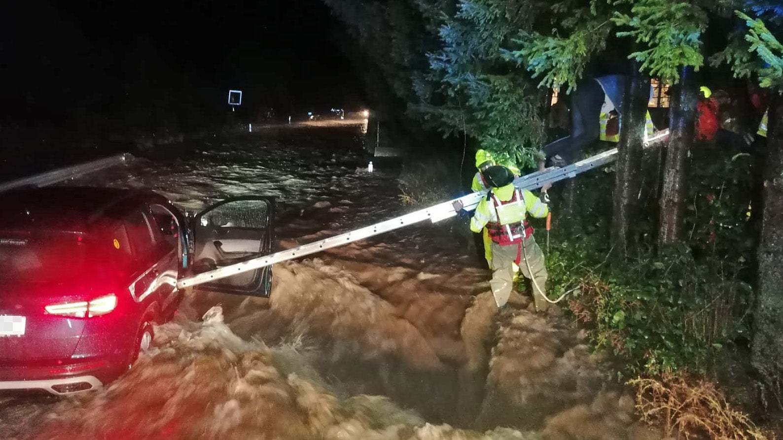 15.09.2024, &Ouml;sterreich, Kirchberg A.D. Pielach: Feuerwehrleute hantieren mit einer Leiter an einem Auto, dass an der zu einem rei&szlig;enden Strom angeschwollenen Pilach steht. Aufgrund der starken Niederschl&auml;ge ist Sonntagfr&uuml;h ganz Nieder&ouml;sterreich zum Katastrophengebiet erkl&auml;rt worden. (FF KIRCHBERG/PIELACH/apa/dpa)