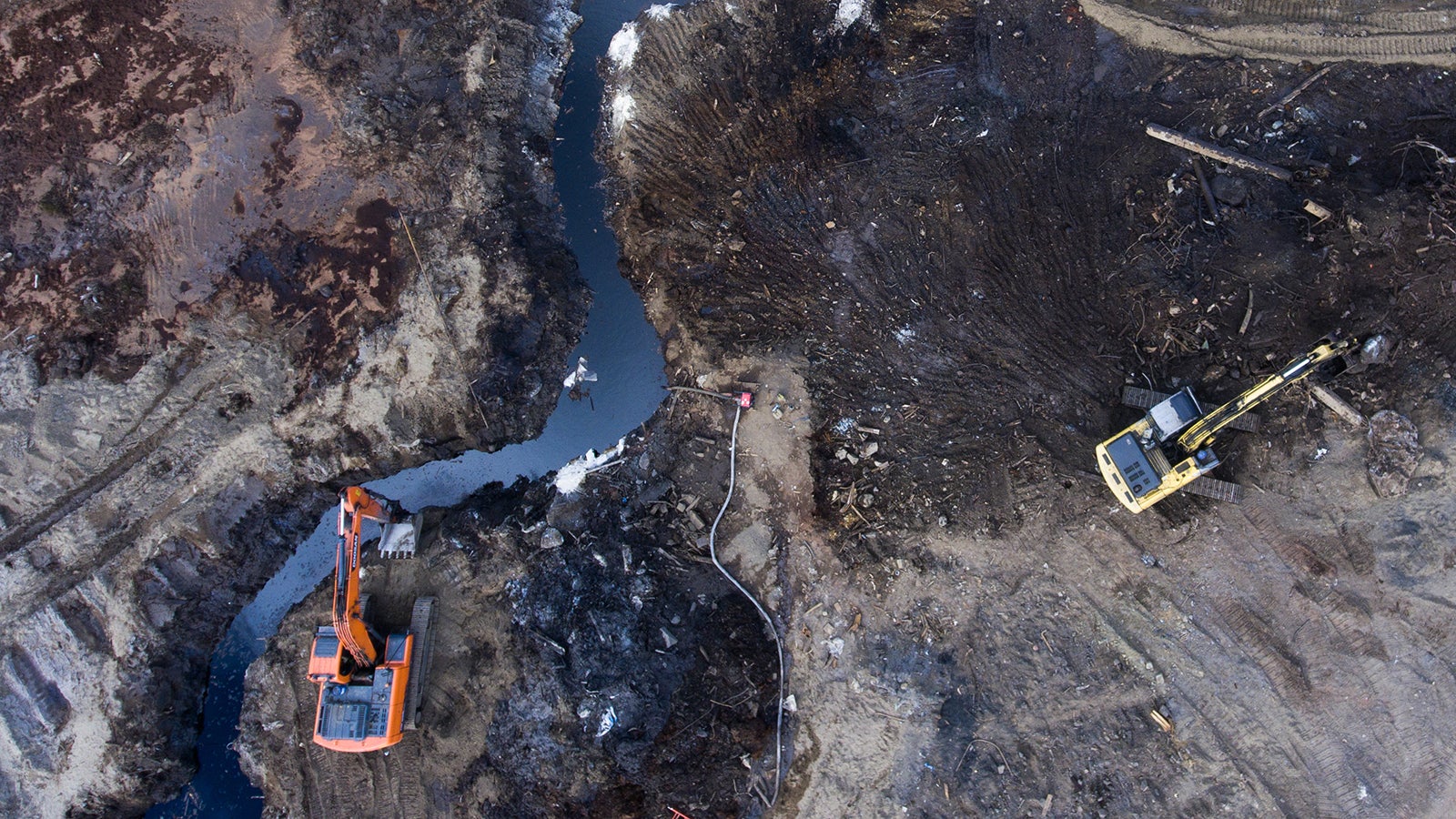 15.06.2020, Russland, Norilsk: Einsatzkr&auml;fte veruchen mit Baggern die Ausbreitung eines &Ouml;lteppichs zu verhindern. Am 29. Mai 2020 st&uuml;rzte das Treibstofflager des Heizkraftwerk ein, 21.000 Tonnen Diesel&ouml;l flossen aus. Rund 15.000 Tonnen sollen in die Gew&auml;sser geraten sein. 6000 Tonnen versickerten demnach im Boden. Hunderte Einsatzkr&auml;fte haben schon tonnenweise verseuchten Boden abgetragen und auch von der Wasseroberfl&auml;che &Ouml;l abgesch&ouml;pft. (zu dpa "Riesige &Ouml;lkatastrophe macht Missst&auml;nde in&nbsp;Russland deutlich") Foto: Kirill Kukhmar/TASS/dpa +++ dpa-Bildfunk +++