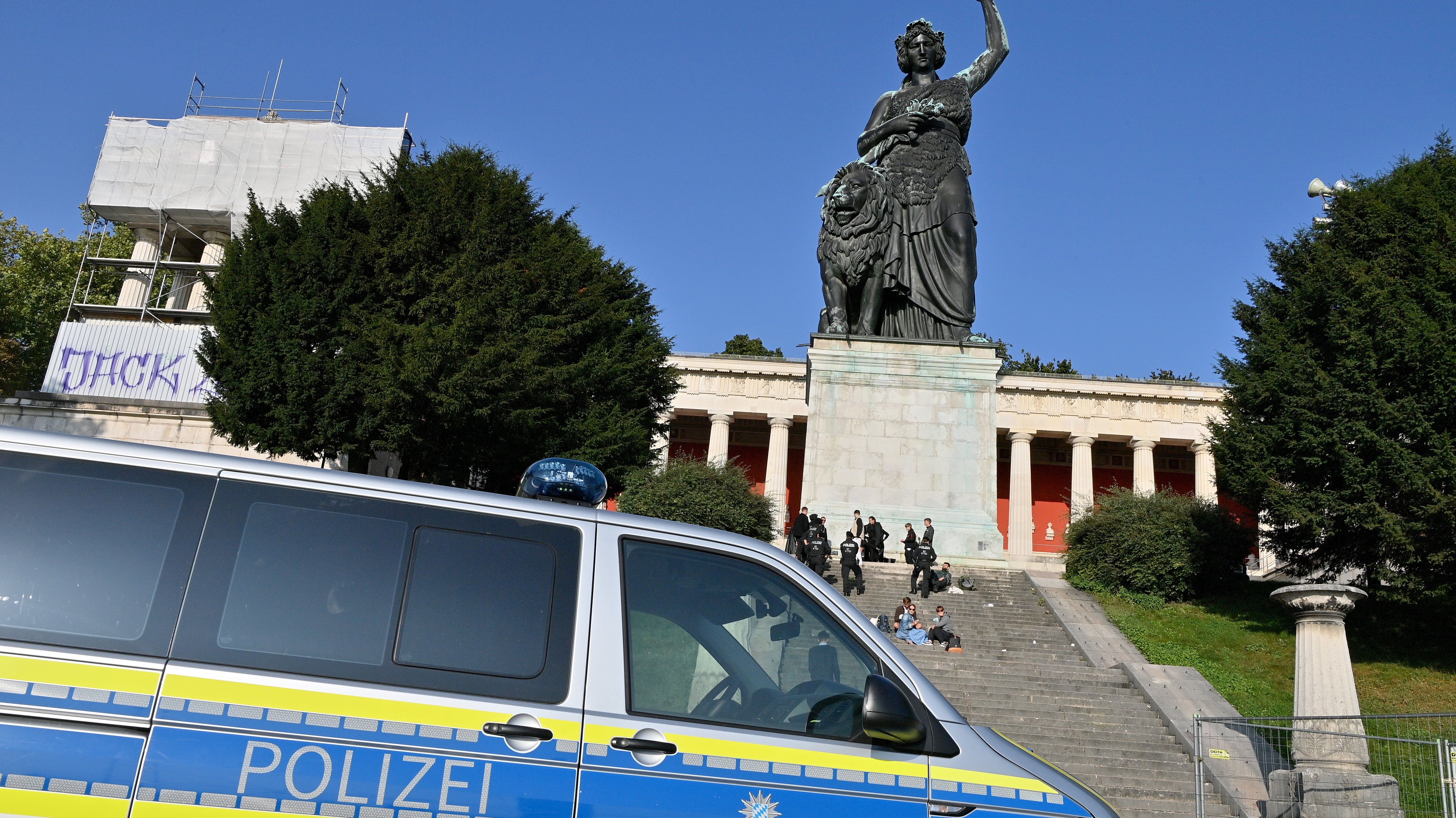Ein Polizeiwagen steht auf dem Wiesn-Gel&auml;nde unterhalb der Bavaria-Statue, Polizisten stehen auf der Treppe vor der Statue.