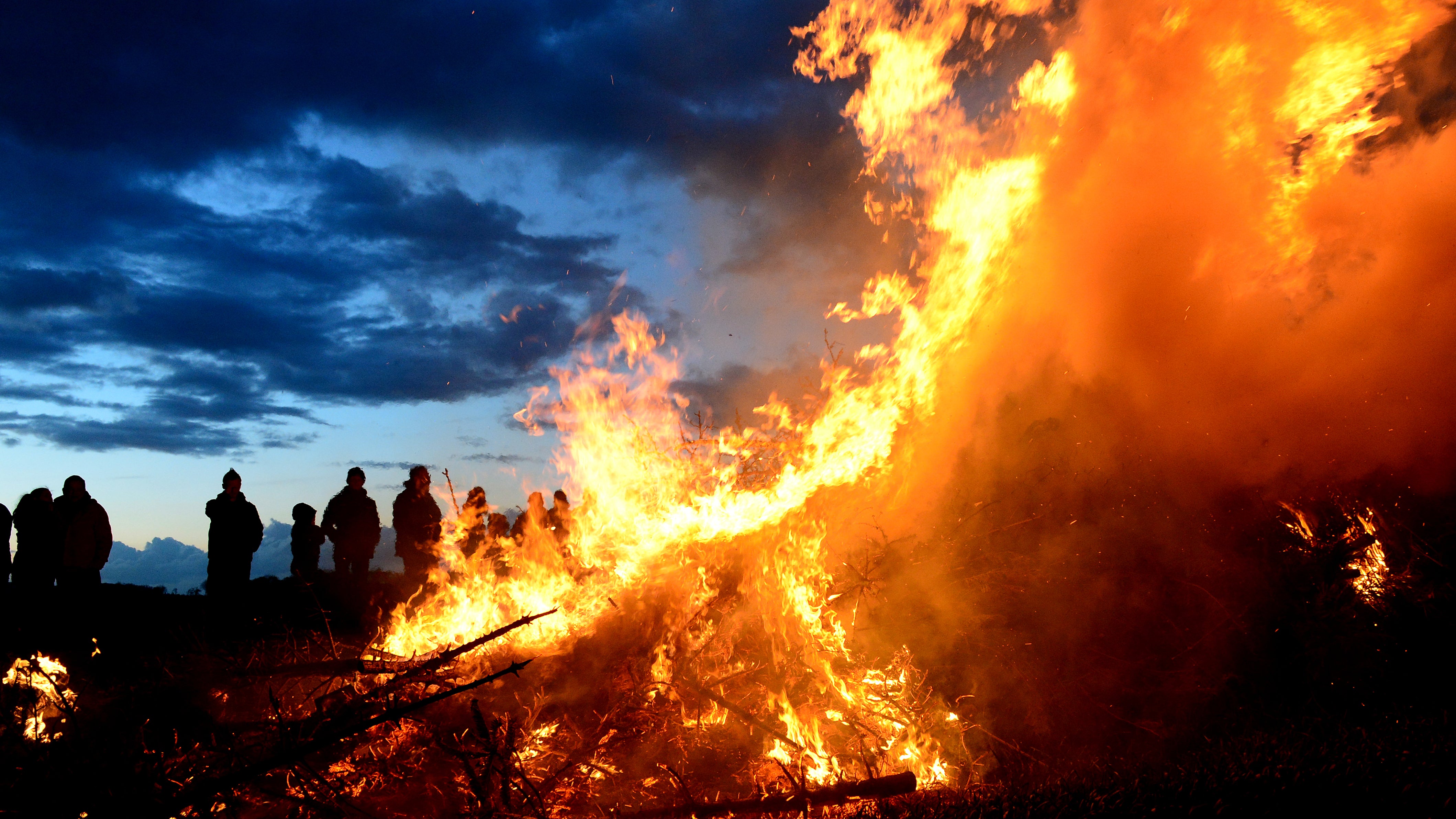 Wartjenstedt: Menschen stehen um ein traditionelles Osterfeuer.