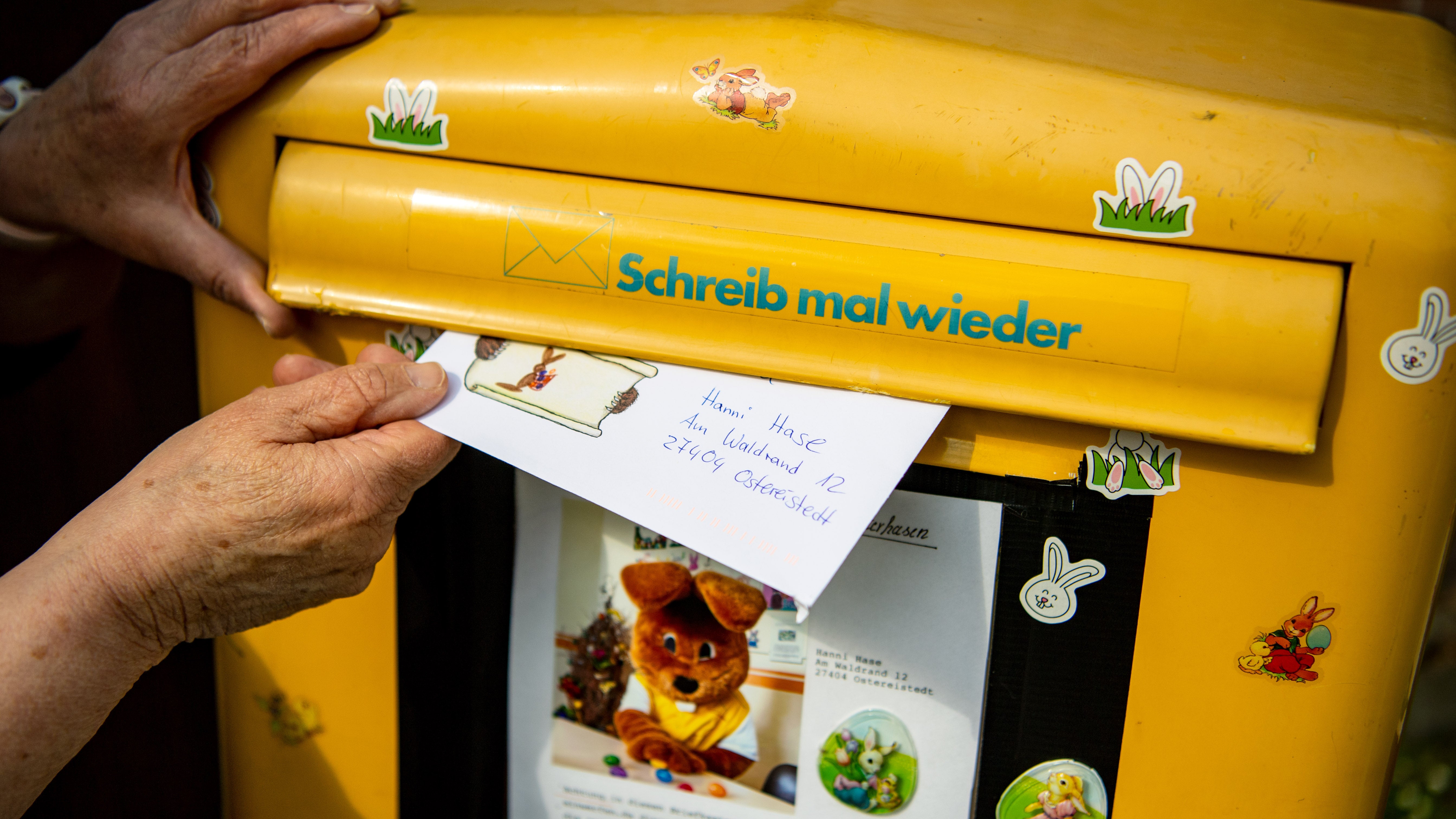 ARCHIV - 14.04.2022, Niedersachsen, Ostereistedt: Ein Brief, den ein Kind f&uuml;r den Osterhasen Hanni Hase geschrieben hat, wird in einen Briefkasten geworfen. (zu dpa: &laquo;Von O bis N &middot; das Osterfest in sechs bunten Fakten&raquo;) Foto: Sina Schuldt/dpa +++ dpa-Bildfunk +++

