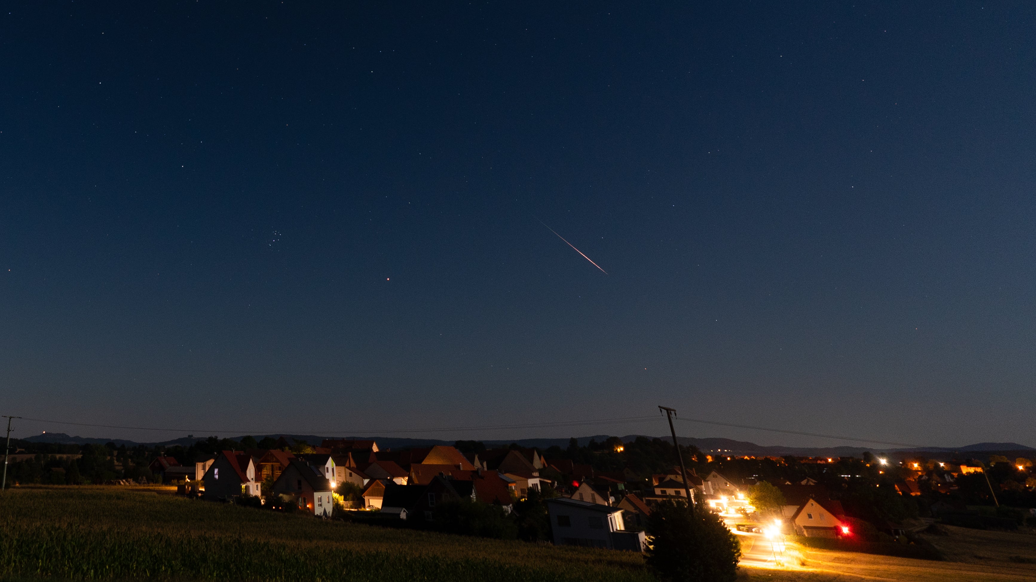 ARCHIV - 12.08.2022, Bayern, H&ouml;fen: Eine Sternschnuppe vergl&uuml;ht am Nachthimmel. In den fr&uuml;hen Morgenstunden am Sonntag wird der allj&auml;hrliche Perseidenschauer sein Maximum erreichen. (Nicolas Armer/dpa)
