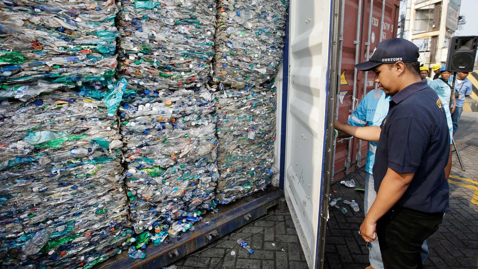 ARCHIV - 18.09.2019, Indonesien, Jakarta: Ein Zollbeamter verschlie&szlig;t einen Container mit Plastikm&uuml;ll am Hafen von Tanjung Priok. Deutschlands Plastikm&uuml;ll-Ausfuhren in andere Staaten sind deutlich gesunken. (Symbolbild zu &laquo;Menge von exportiertem Plastikm&uuml;ll sinkt um ein Drittel&raquo;) Foto: Achmad Ibrahim/AP/dpa +++ dpa-Bildfunk +++