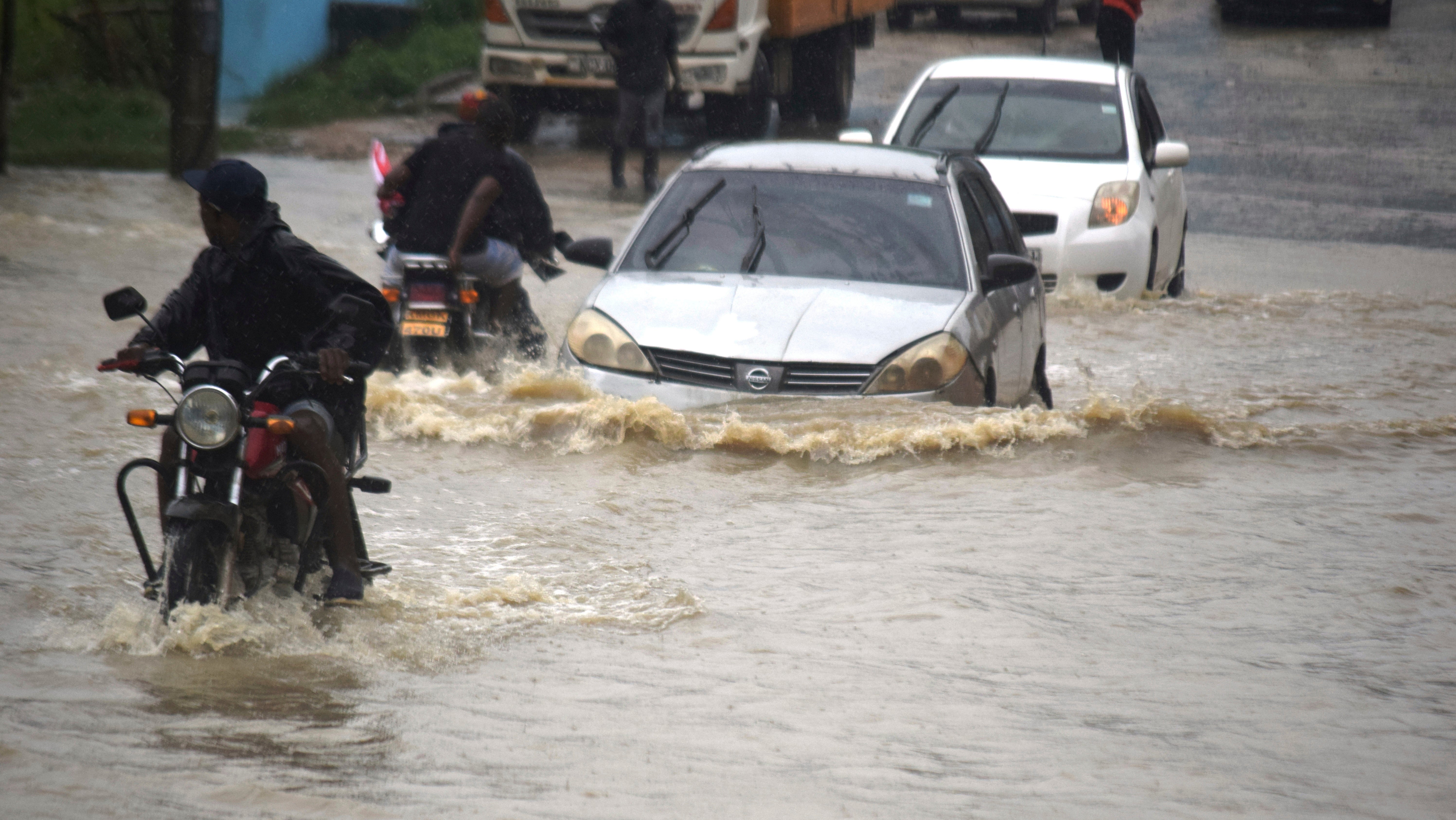Autofahrer waten nach einem heftigen Regenguss am Freitag, dem 3. November 2023, durch eine &uuml;berflutete Stra&szlig;e in der Stadt Mombasa. (AP Photo/Gideon Maundu, File)

